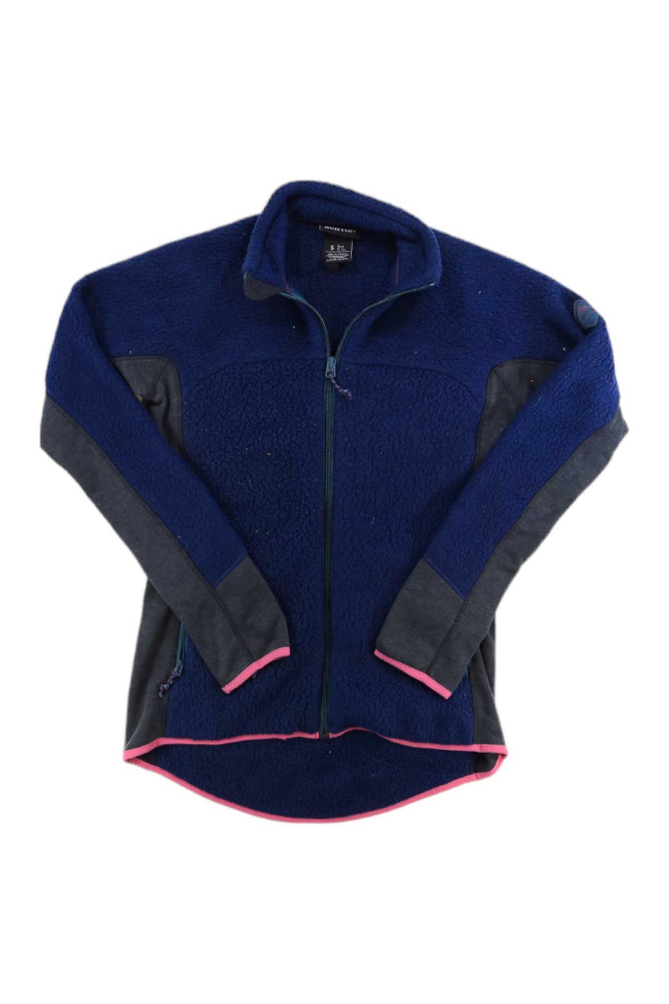 The Burton Womens Minturn Full Zip Jacket is a navy blue Polartec fleece zip-up with dark gray sleeve and side panels, pink trim on cuffs and hem, and a high collar. The snowboard jacket is shown laid flat on a white background.
