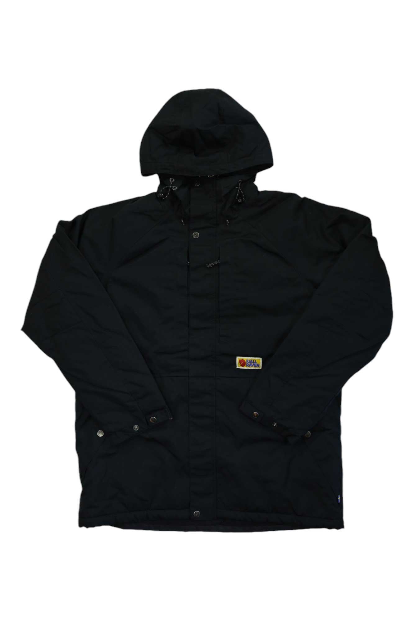 The Fjallraven Men's Vardag Lite Padded Jacket is a black hooded jacket with front snap buttons, adjustable hood drawstrings, and a small patch logo near the hem. Made from G-1000 Eco fabric and recycled polyester insulation. Relaxed fit, long sleeves.