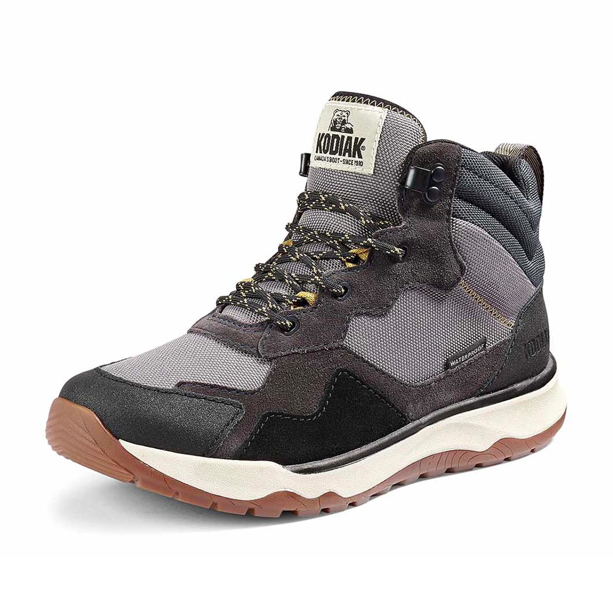 The Kodiak Women's Kenosee Mid Cut Waterproof Hiking Boot, shown on a white background, features a gray and black high-top design with rugged soles, yellow and black laces, and "KODIAK" branding on the tongue.