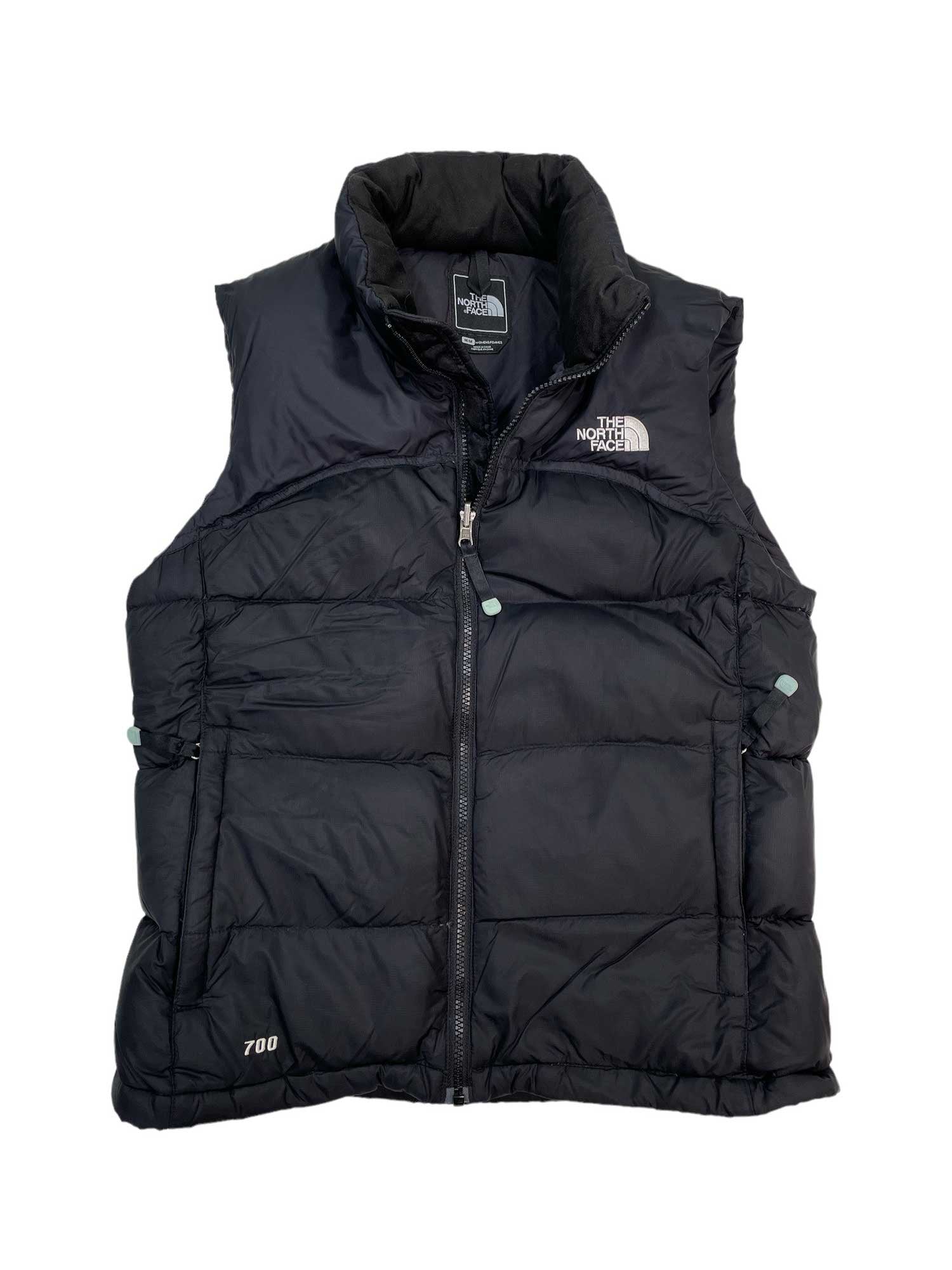 The Women's Nuptse Vest is a black insulated vest with a front zipper, high collar, The North Face logo on the chest, and "700" stitched near the bottom left to indicate its warm down fill power.