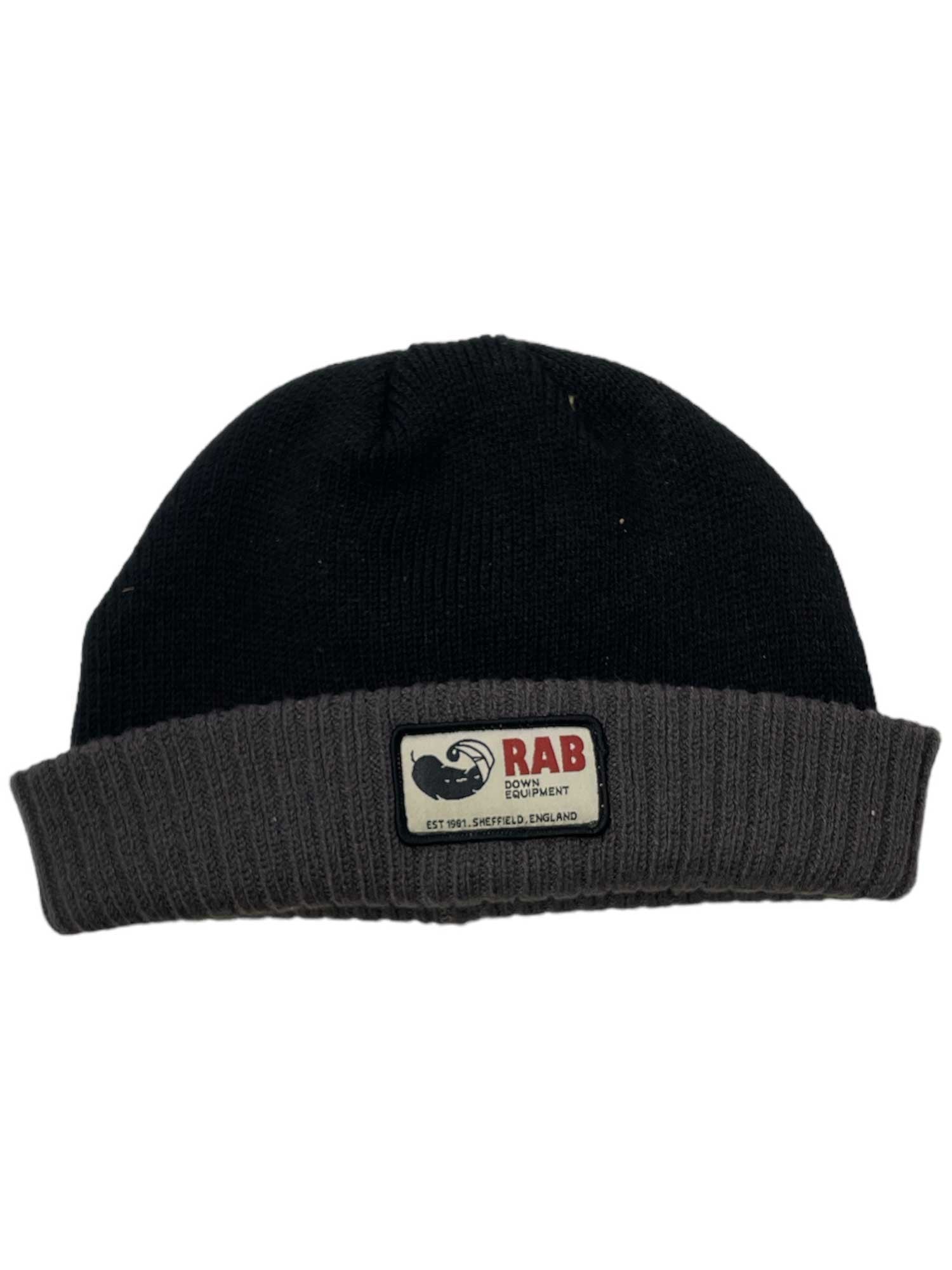The Rab Essential Beanie is black with a gray folded brim, made from recycled polyester. It features a rectangular RAB Equipment patch with Est. 1981, Sheffield, England, and a mountain logo—ideal for everyday casual wear.