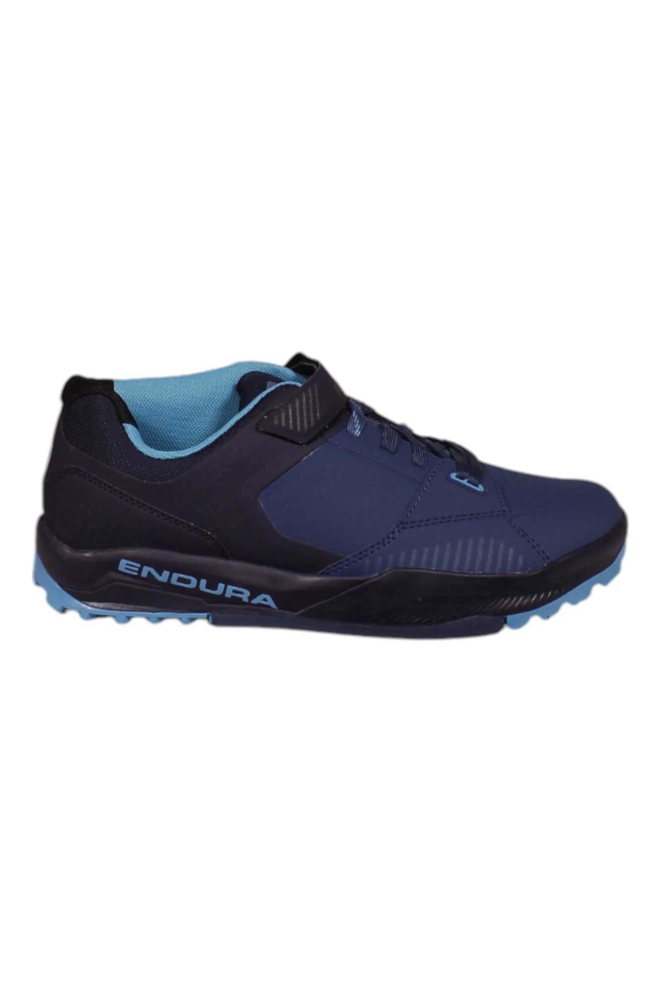 The Endura Mens MT500 Burner Flat Shoe is a navy blue athletic shoe with black and light blue accents, light blue laces, ENDURA branding on the side, and a StickyFoot Rubber sole for superior grip—ideal for mountain bike flat pedal riding.