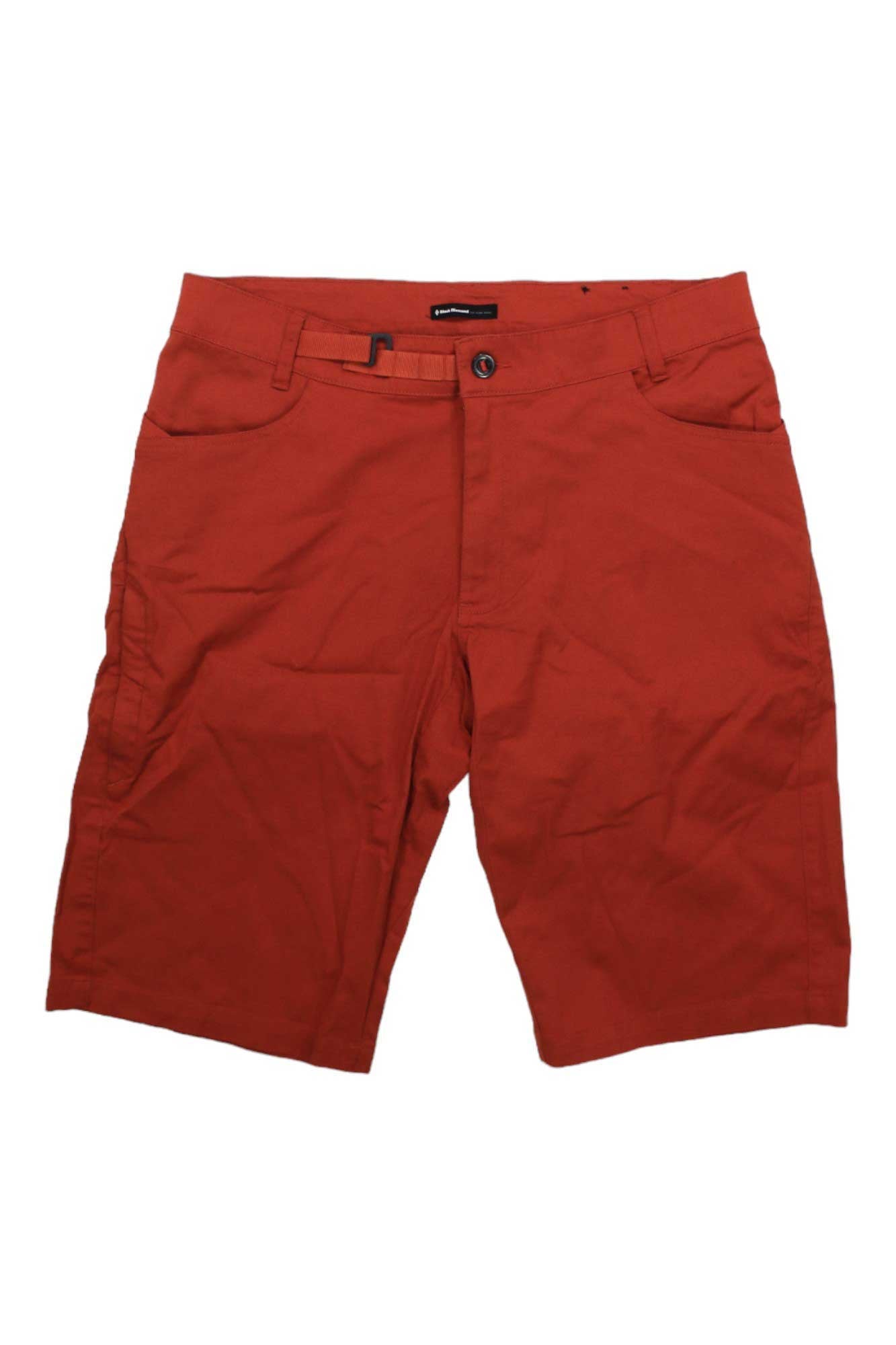The Black Diamond Mens Credo Short is a pair of red, knee-length climbing shorts made from organic cotton with front pockets, belt loops, button and zipper closure, and an adjustable waistbelt, shown against a white background.