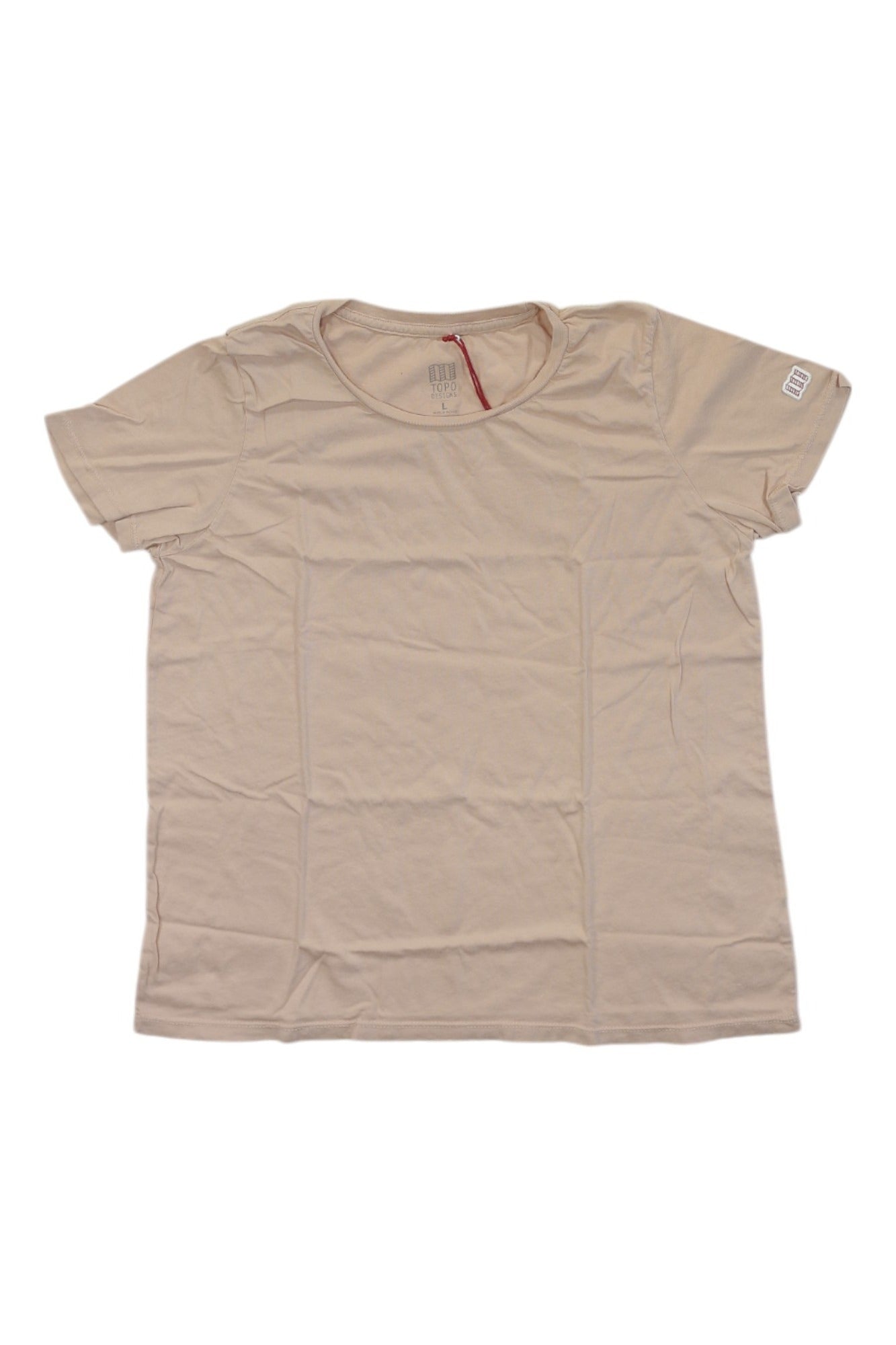 The Topo Designs Womens Classic Tee is a plain beige, short-sleeved t-shirt with a round neckline, shown laid flat on a white background. Slightly wrinkled, it's made from sustainable fabric for everyday comfort.