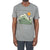A person wears the Moosejaw Men's Fried Pickle SS Tee, a casual short sleeve shirt with a graphic of mountains, a setting sun, and a small red figure on a peak. The vintage washed tee pops against the plain white background.