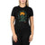 A woman wears the Moosejaw Womens Dandelion Tea SS Tee, crafted from organic cotton with an orange flower and green leaves graphic. "LEAF IT AS YOU FOUND IT" arcs above the design as she stands with arms relaxed by her sides.