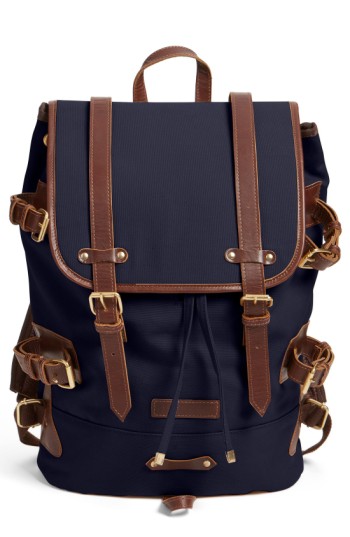 Navy canvas tier backpack with tan leather trim, flap front, and adjustable shoulder straps