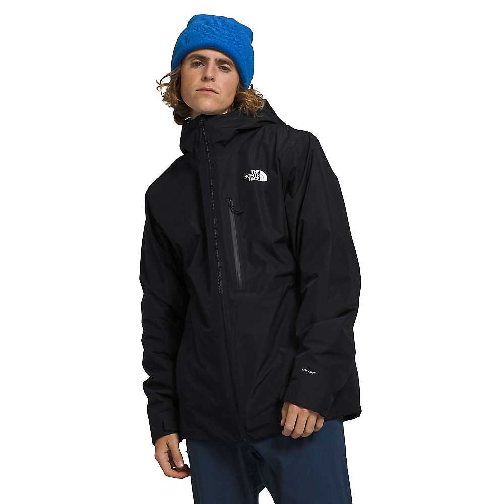 A person wearing a blue beanie and The North Face Men's North Table Down Triclimate Jacket stands with a relaxed posture against a white background.