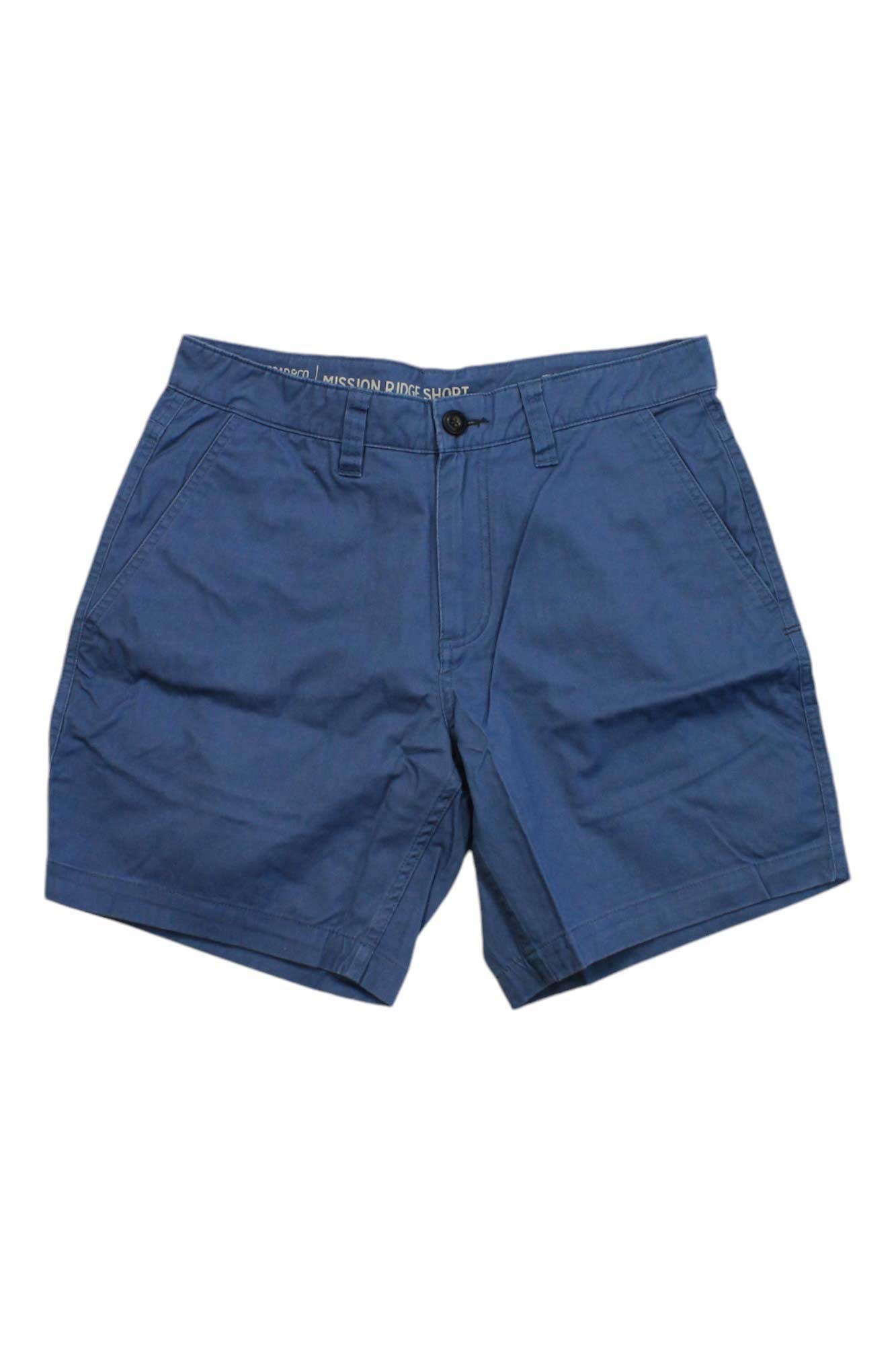 The Toad & Co Mens Mission Ridge 8 Inch Short in blue features front pockets, belt loops, button and zipper closure, and subtle creases—ideal sun-protective organic cotton shorts for hiking or casual outings.
