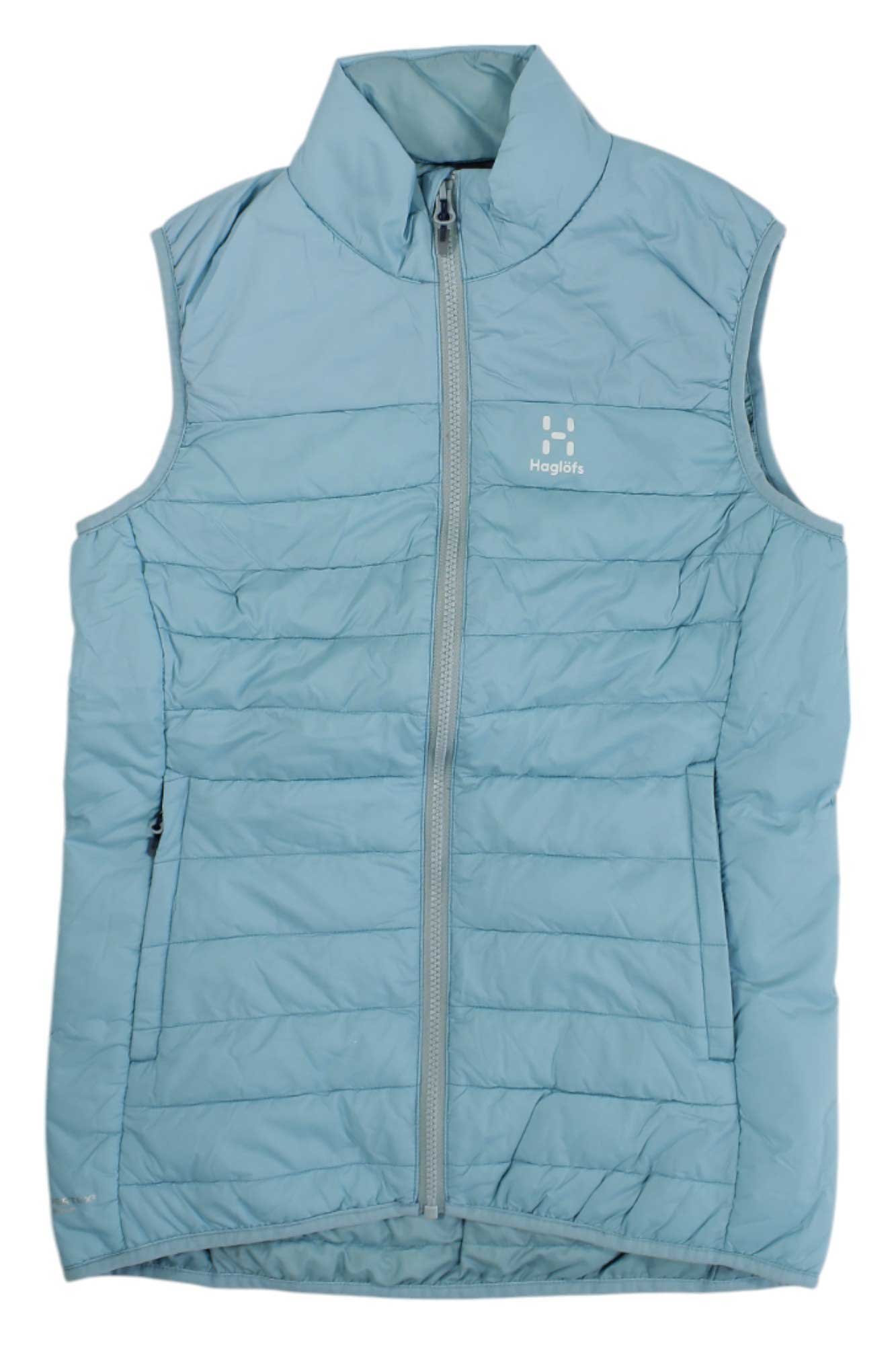 The Haglofs Womens Spire Mimic Vest is a light blue, sleeveless, water-resistant vest with synthetic insulation, a high collar, front zipper, horizontal stitching, and a small Haglöfs logo on the left chest.