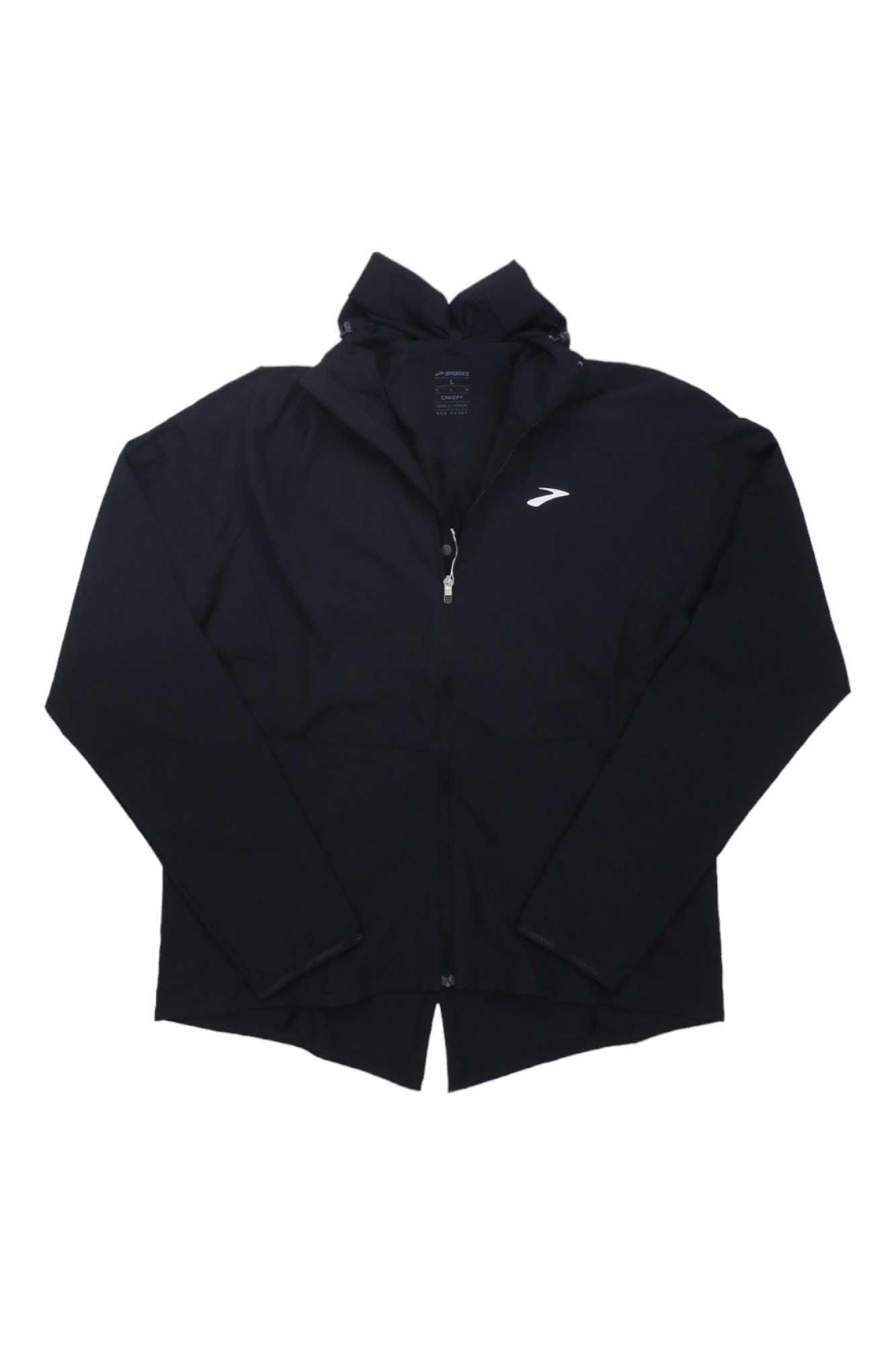 The Brooks Womens Canopy Jacket, shown in black with a zip-up hood, long sleeves, and white chest logo, is windproof and waterproof—ideal for hiking or trail running.