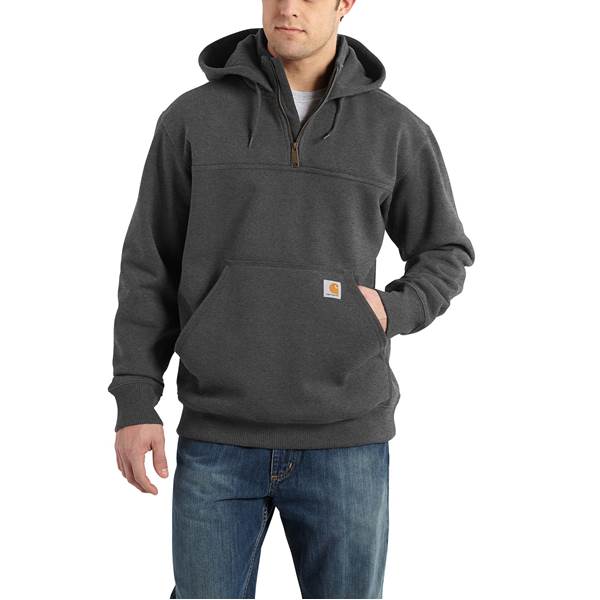 A man wearing a Rain Defender Loose Fit Heavyweight Quarter-Zip Sweatshirt and blue jeans stands with one hand in his pocket against a plain white background.