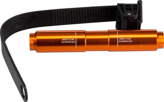 The Kuat Trio Fork Adapter, an orange tire lever tool with “Insert to line on driver’s side” text and a black strap, is a handy bike rack accessory ideal for bicycle maintenance.
