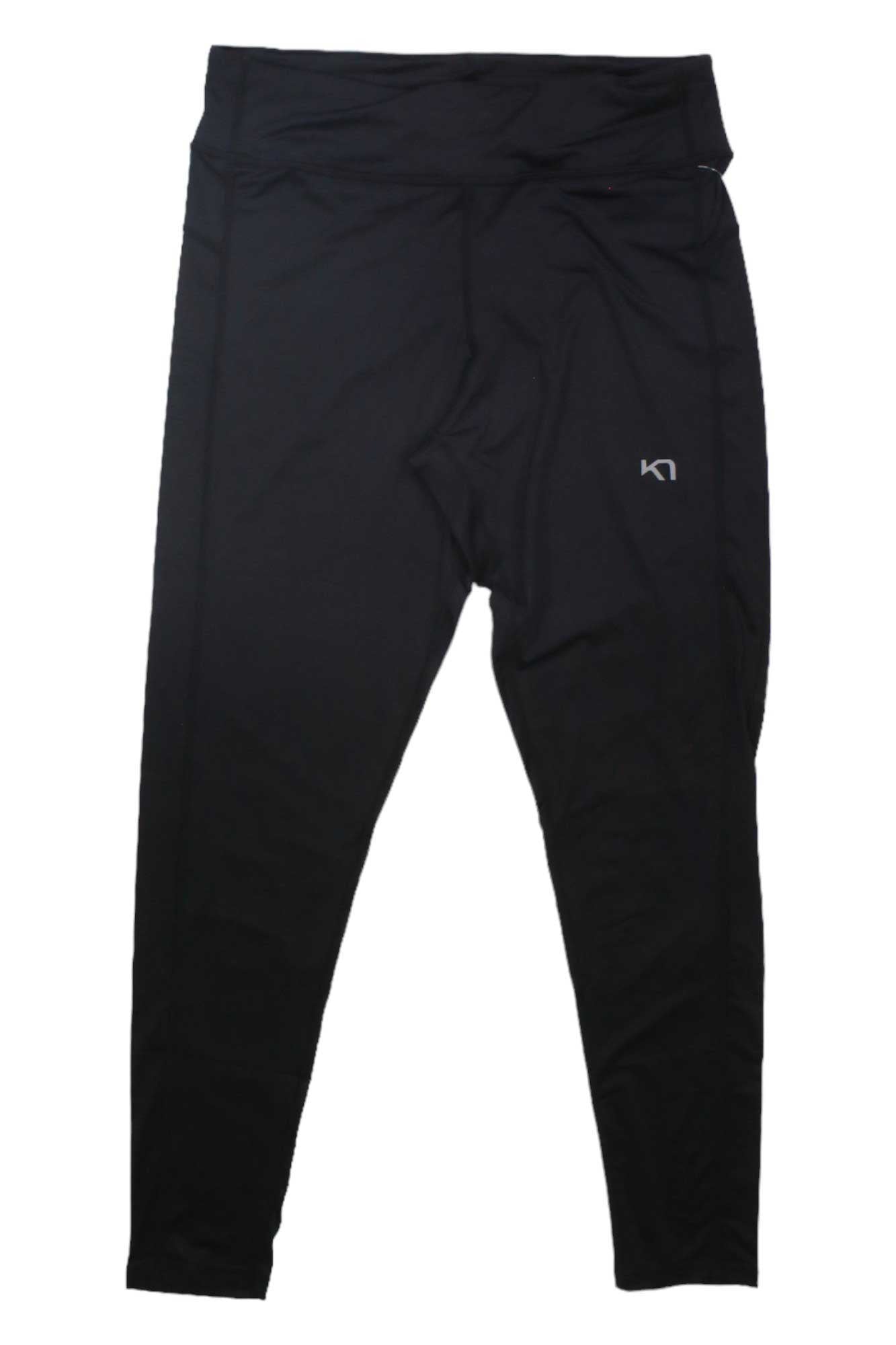 The Kari Traa Women's Nora 2.0 Tight is a pair of black, high-waisted hiking tights for women with a small white logo on the left thigh and 4-way stretch material, shown laid flat on a white background.