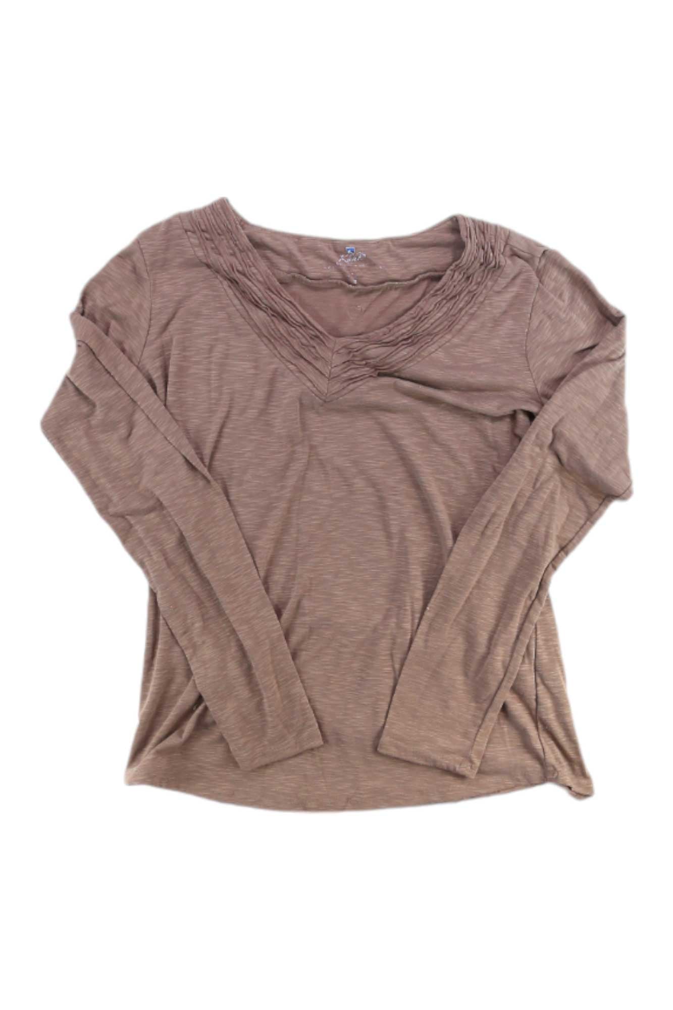 The Kuhl Womens Casual Long Sleeve Top in light brown features a V-neckline with subtle pleated detailing, making it a versatile addition to any wardrobe. Shown laid flat on a white background.