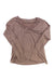 The Kuhl Womens Casual Long Sleeve Top in light brown features a V-neckline with subtle pleated detailing, making it a versatile addition to any wardrobe. Shown laid flat on a white background.