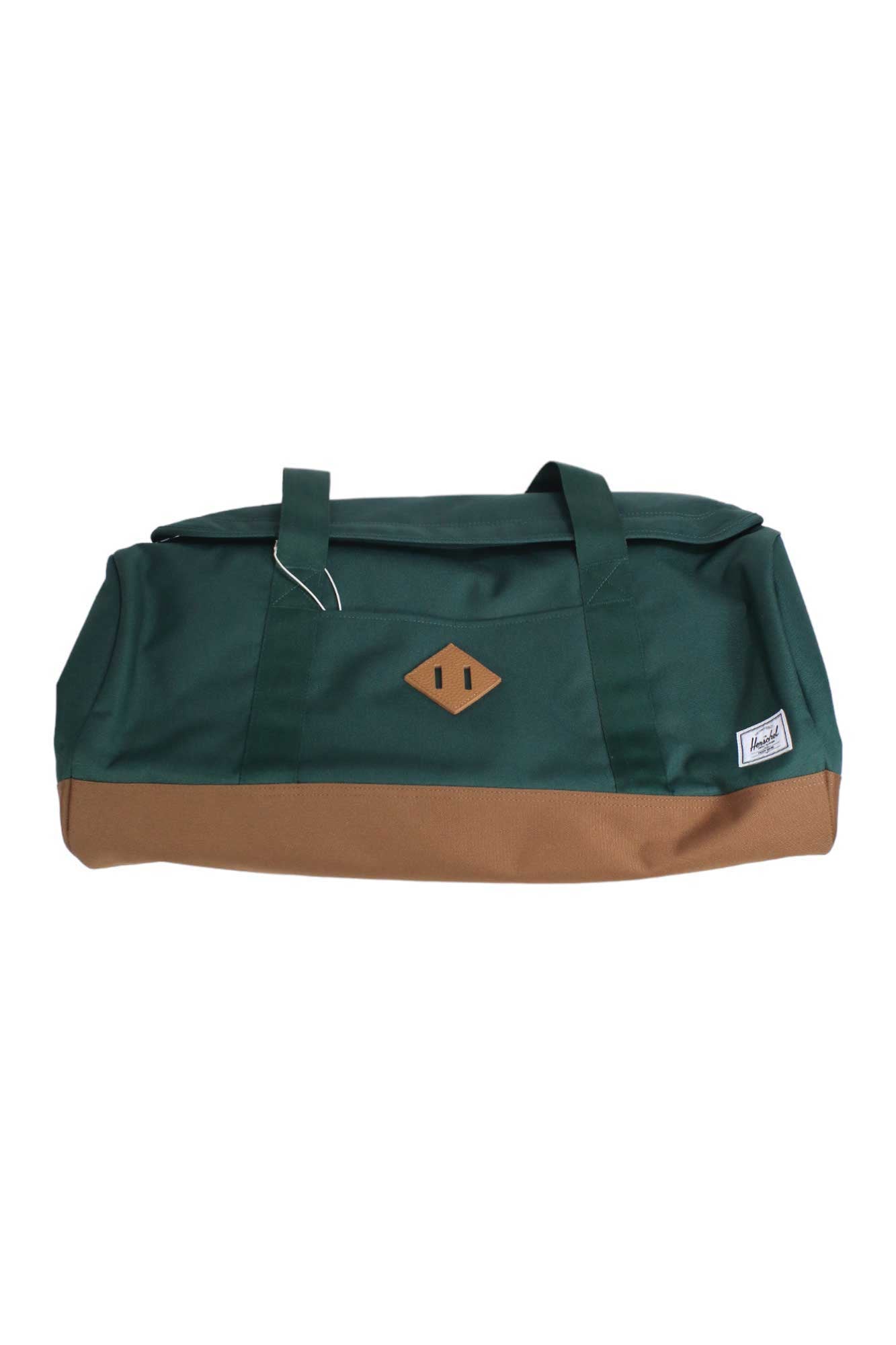 The Herschel Supply Company Heritage Duffle is a green bag made with EcoSystem 600D fabric, brown accents, two handles, a front diamond-shaped leather patch, and a small white label—ideal for travel.