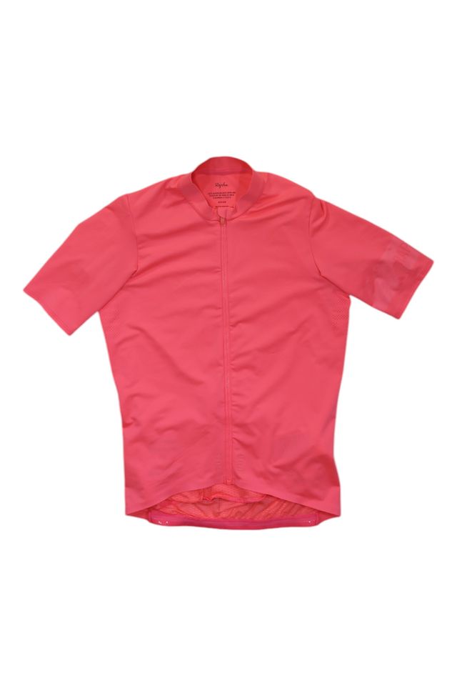 The Mens Pro Team Midweight Short Sleeve Jersey, in bright pink, features a full front zipper, flat collar, short sleeves, and a slightly longer back hem. It's displayed on a white background.
