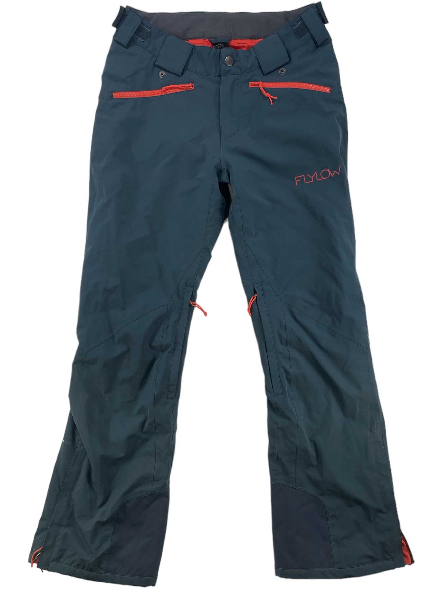 These Daisy Insulated Pants by Flylow are dark green, waterproof ski pants with red zippers and accents, multiple pockets, an adjustable waist, and reinforced cuffs.