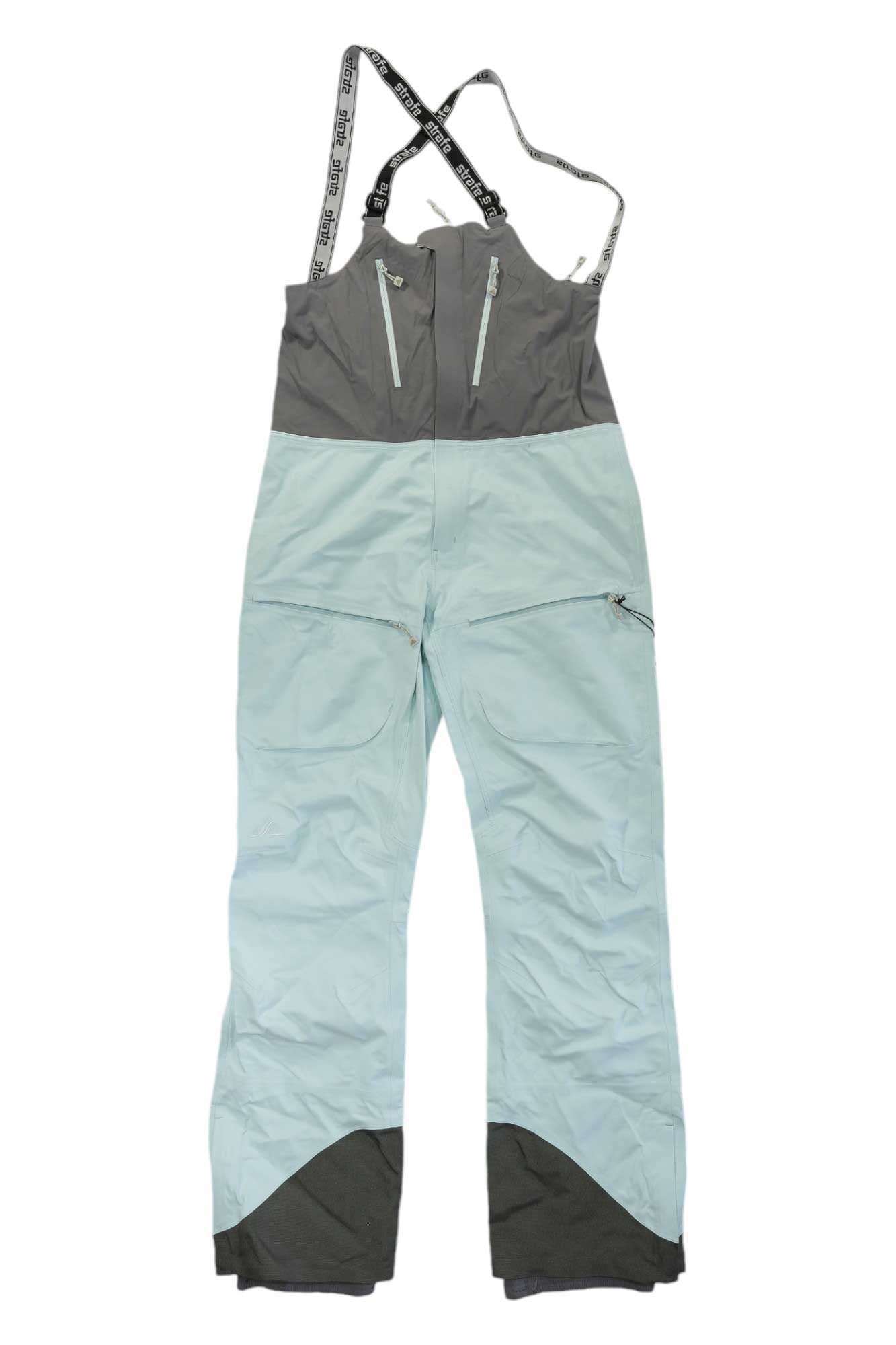 Strafe Womens Scarlett Bib in light blue and gray eVent DV Alpine fabric with adjustable black suspenders, zippered chest and thigh pockets, reinforced ankle cuffs; breathable waterproof ski pants shown laid flat, front side up.