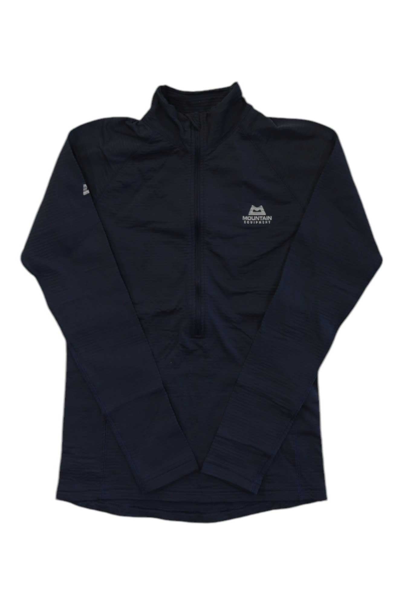 The Mountain Equipment Womens Solar Eclipse Zip Tee is a black, long-sleeve fleece performance midlayer with a small white mountain logo and "Mountain Equipment" on the left chest, shown laid flat on a white background.