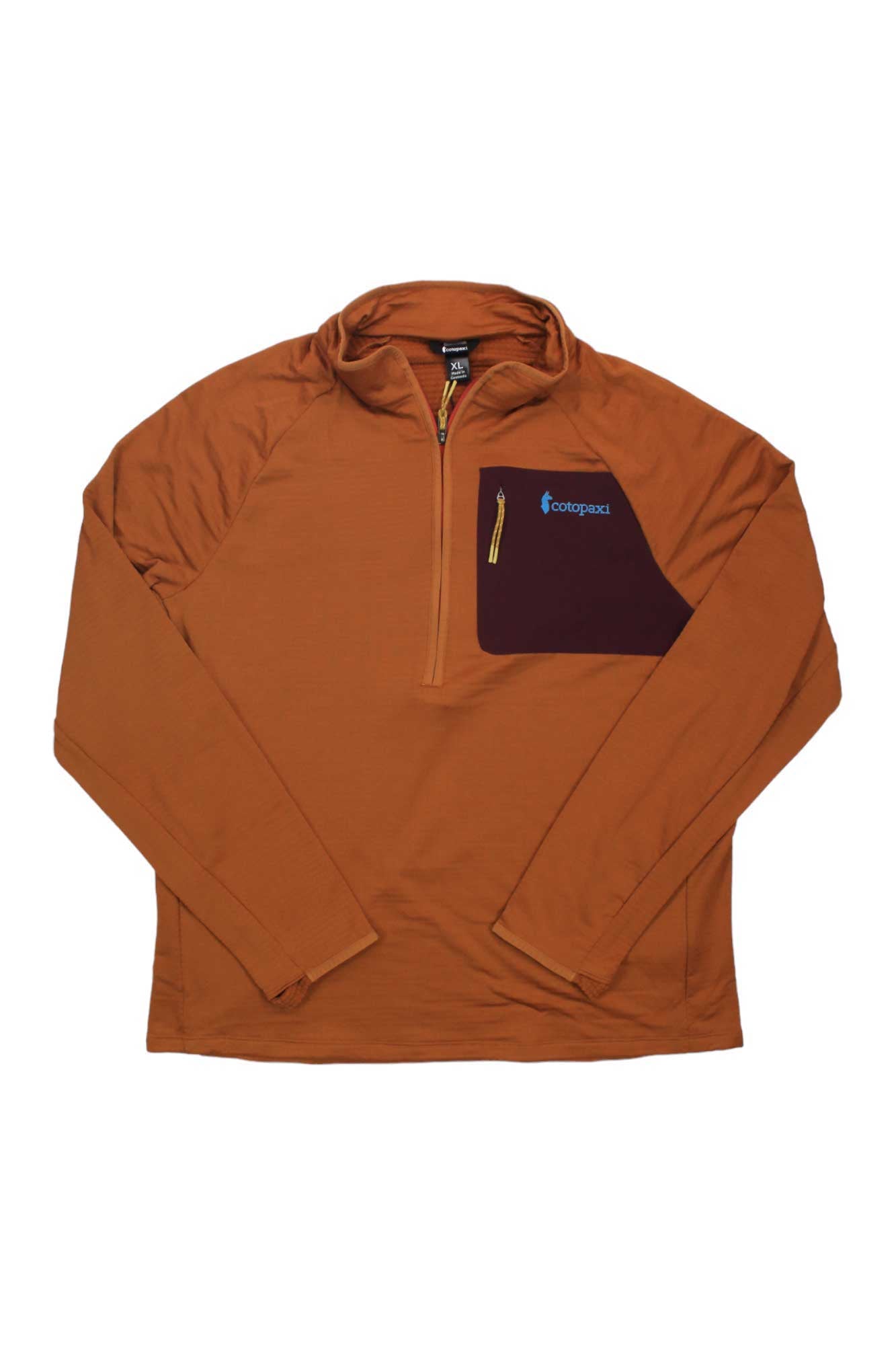 The Cotopaxi Otero Fleece Half-Zip Pullover features long rust-orange sleeves, a dark purple chest pocket, and a yellow zipper with logo detailing—ideal for hiking and crafted from recycled materials.