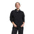 A person wears The North Face Womens Pali Pile Fleece 1/4 Snap in black and matching black pants, both made from recycled polyester, standing against a white background with one hand in their pocket and the other by their side.