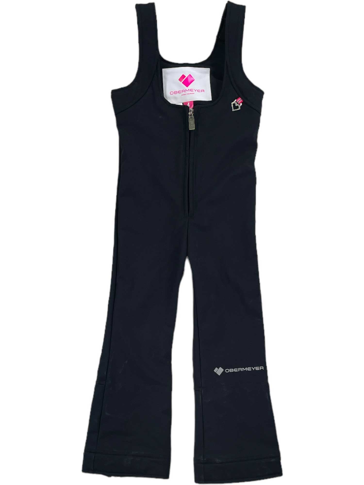 The Girls Snell Stretch Pant is a black, overall-style ski pant with a front zipper, wide straps, flared legs, water-resistant fabric, and small logos on the chest and left thigh.