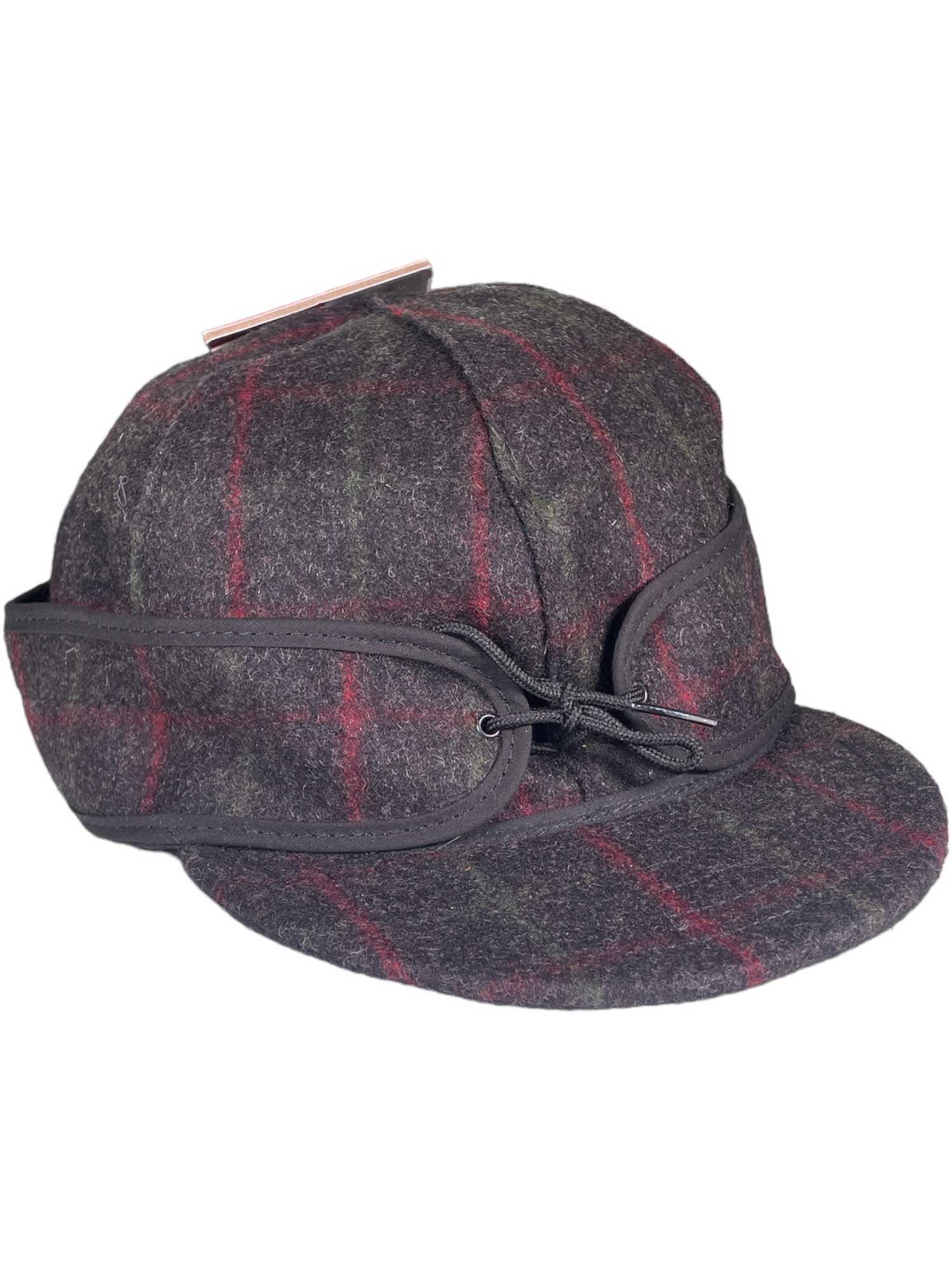 The Stormy Kromer Original Cap features red and green plaid, cozy ear flaps, black trim, and a drawstring—making it the perfect outdoor hat for chilly days.