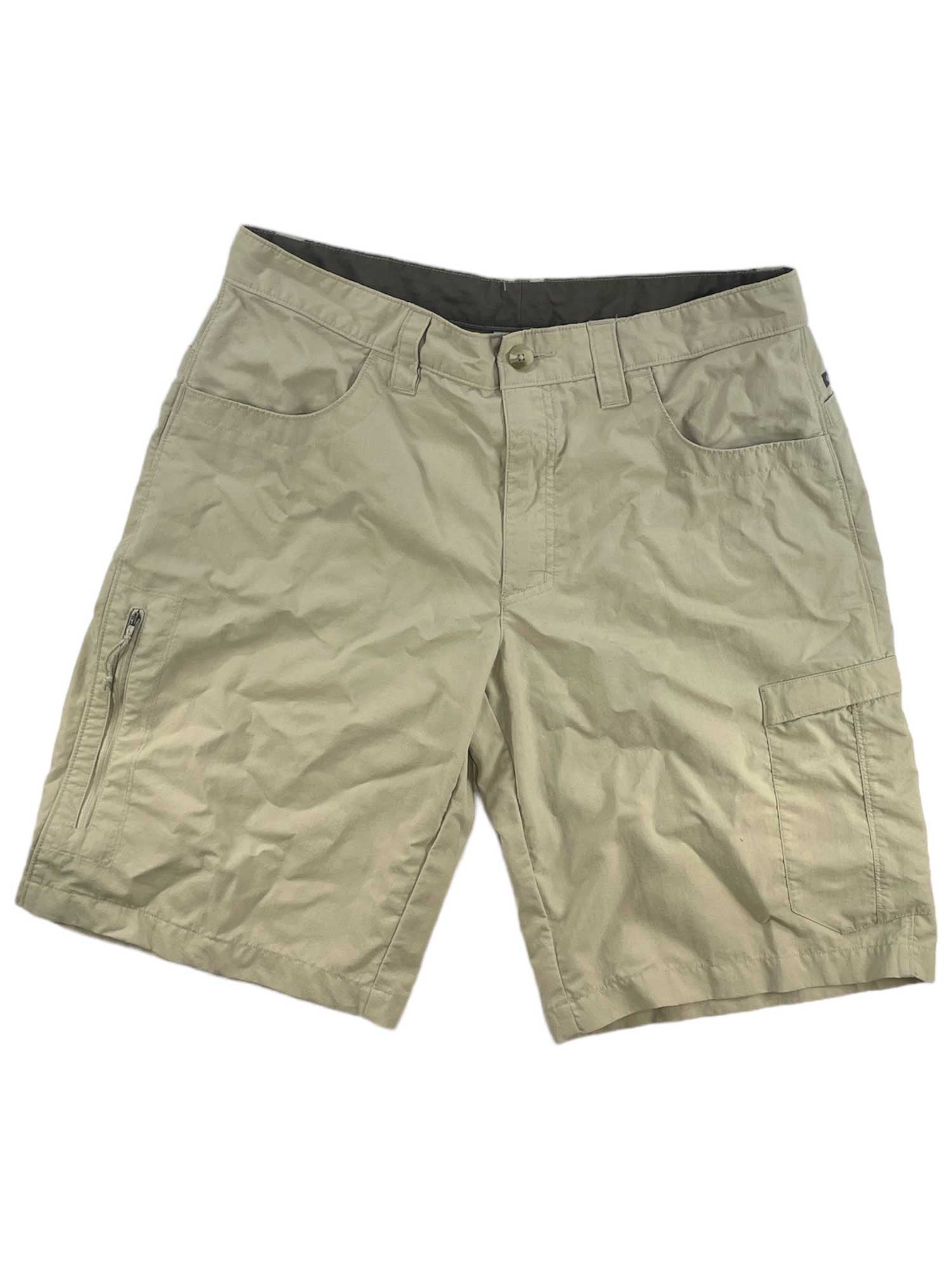 Mens Columbia Hiking Shorts in light khaki, featuring multiple pockets including a zippered left leg pocket and button waist closure, are perfect for hiking and shown laid flat on a white background.