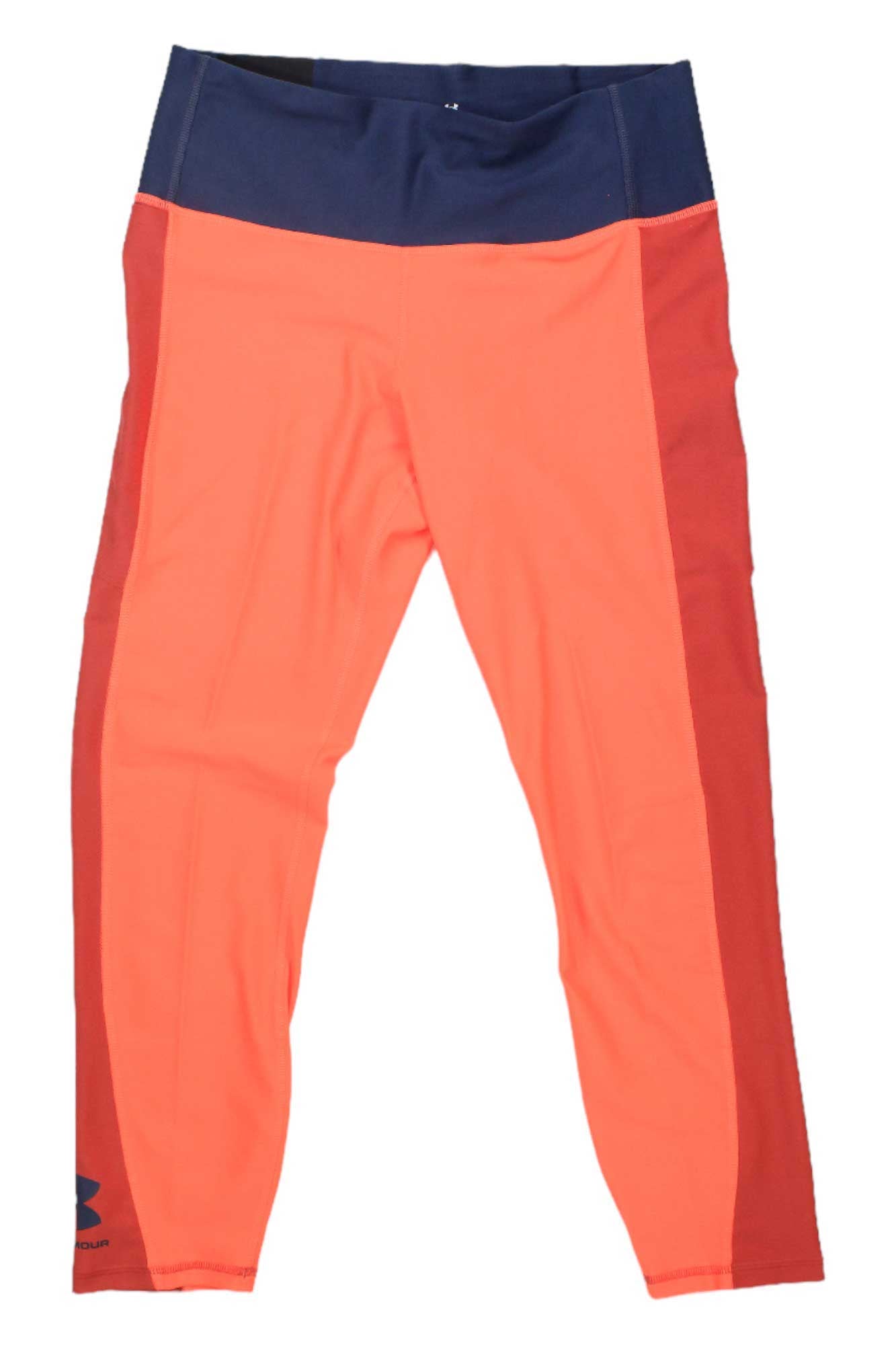 The Under Armour Womens Armour Blocked Ankle Legging features orange-red legs, a high-rise navy blue waistband, moisture-wicking fabric, and a subtle logo near the left ankle.