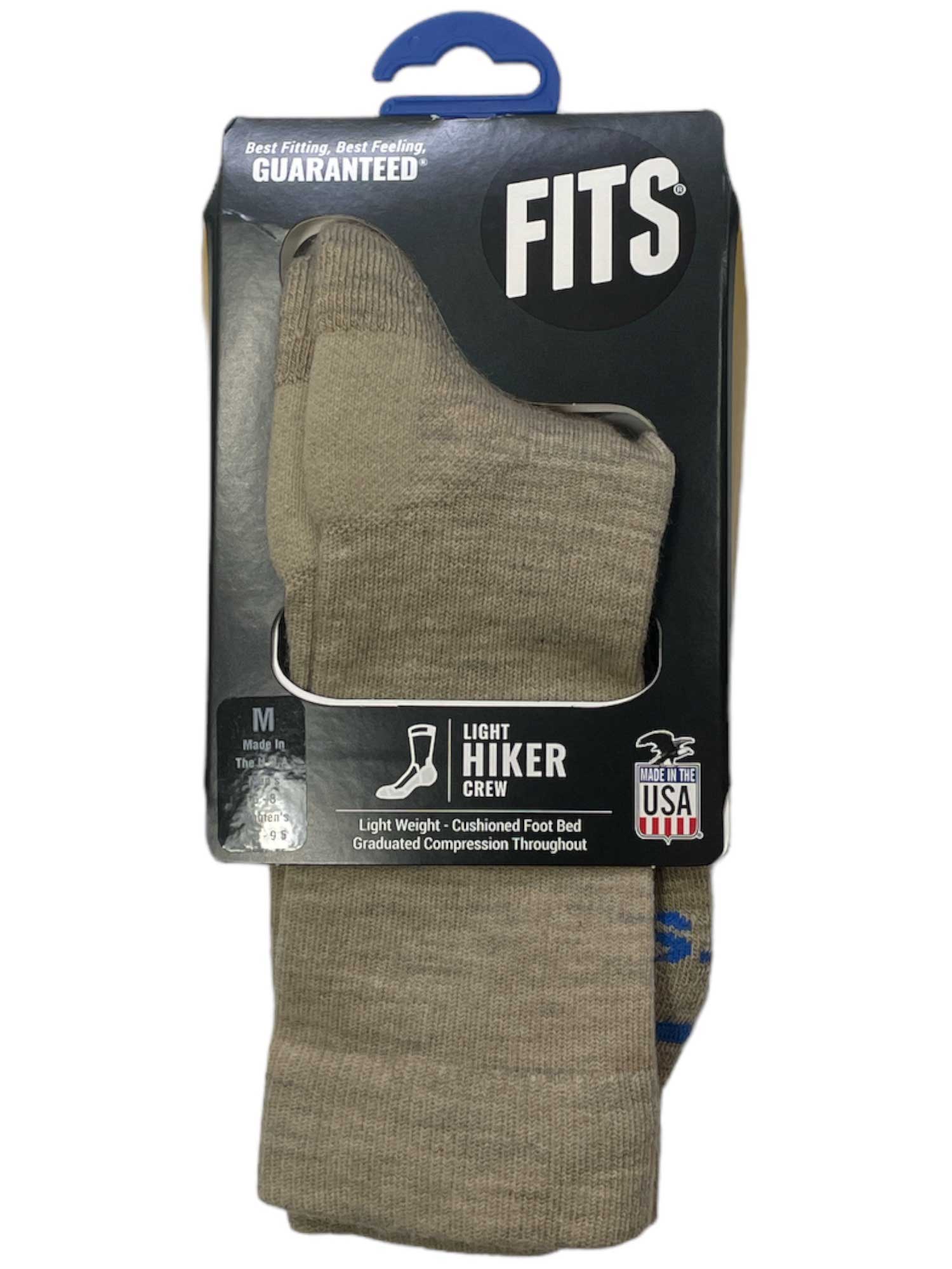 The Fits Light Hiker Crew Sock, size medium and made with soft Merino Wool, features a black and silver label stating "Best Fitting, Best Feeling, Guaranteed" and "Made in USA"—ideal for trail comfort.