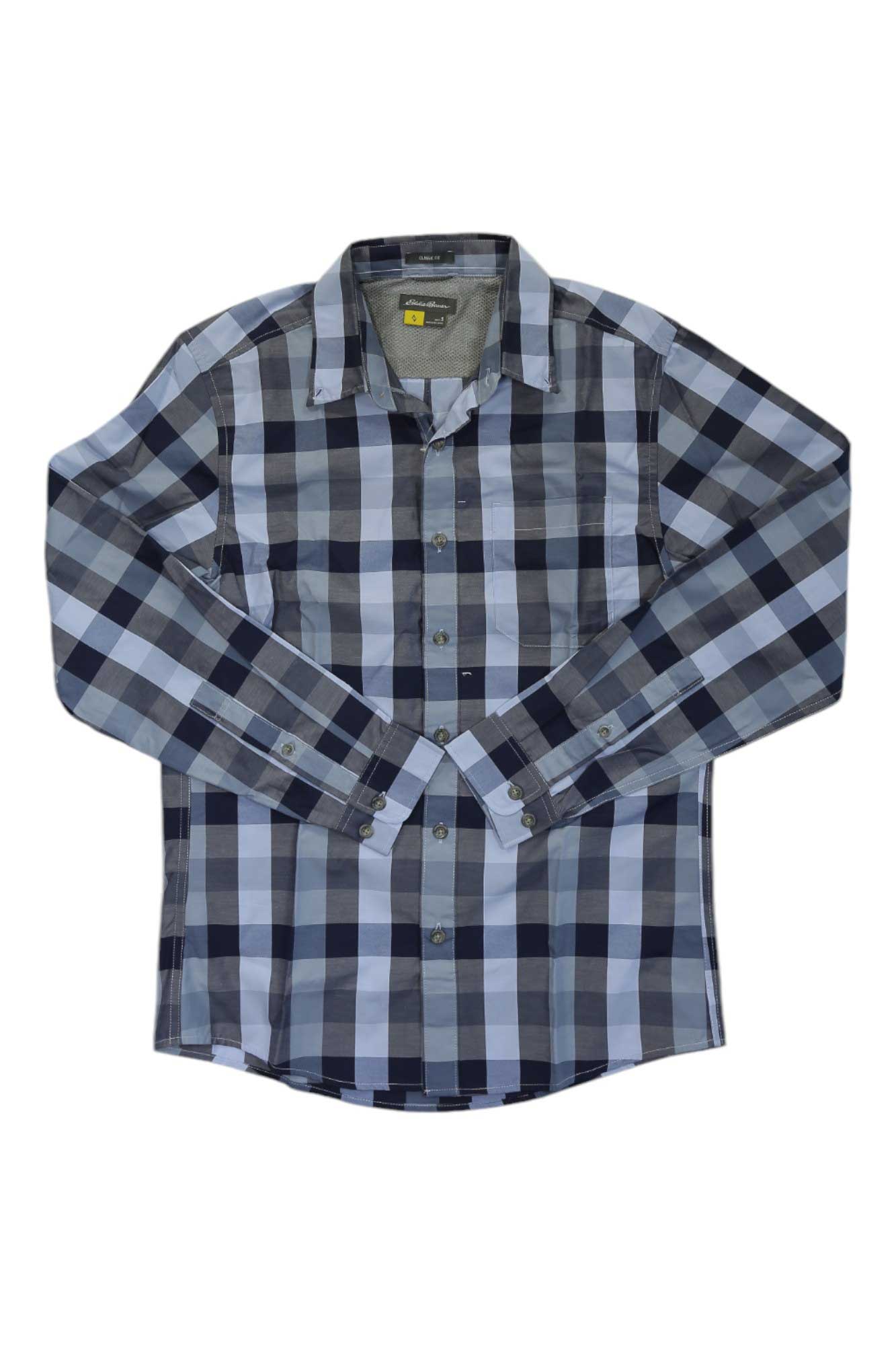 The Eddie Bauer Travex Men’s On the Go Long Sleeve Poplin Shirt, featuring a blue, black, and white plaid pattern, is shown laid flat on a white background.