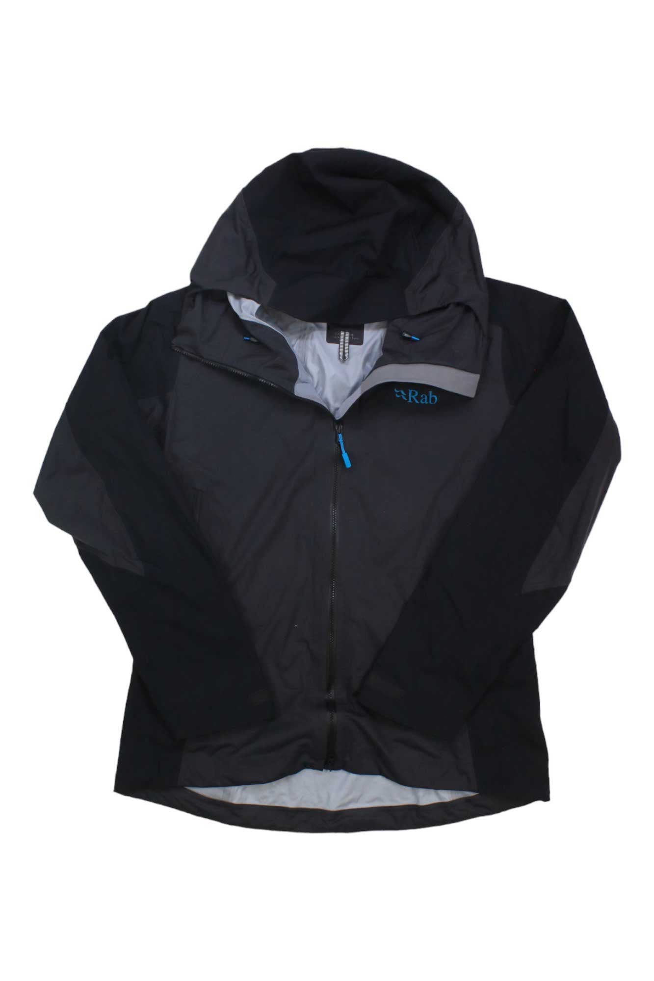 A black Rab Womens Kinetic Alpine 2.0 Jacket is laid flat with the top unzipped, showing a light gray interior lining and blue zipper. The Rab logo appears on the left chest of this waterproof technical shell.