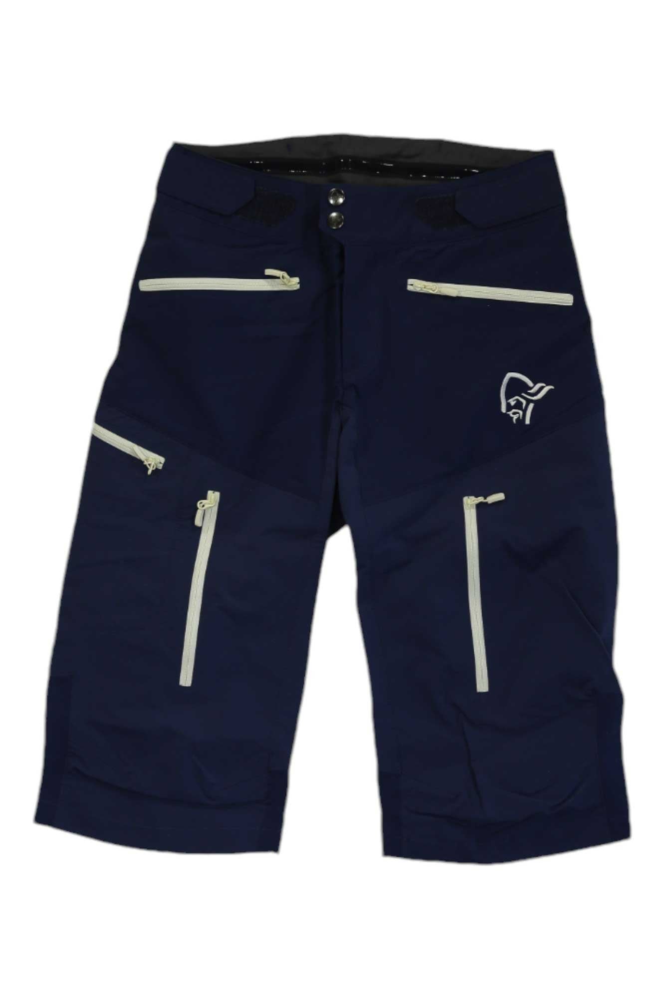 The Norrona Women's Fjora Flex1 Short is a pair of dark blue recycled nylon shorts with multiple white zippered pockets and a white logo on the right thigh, shown against a white background.