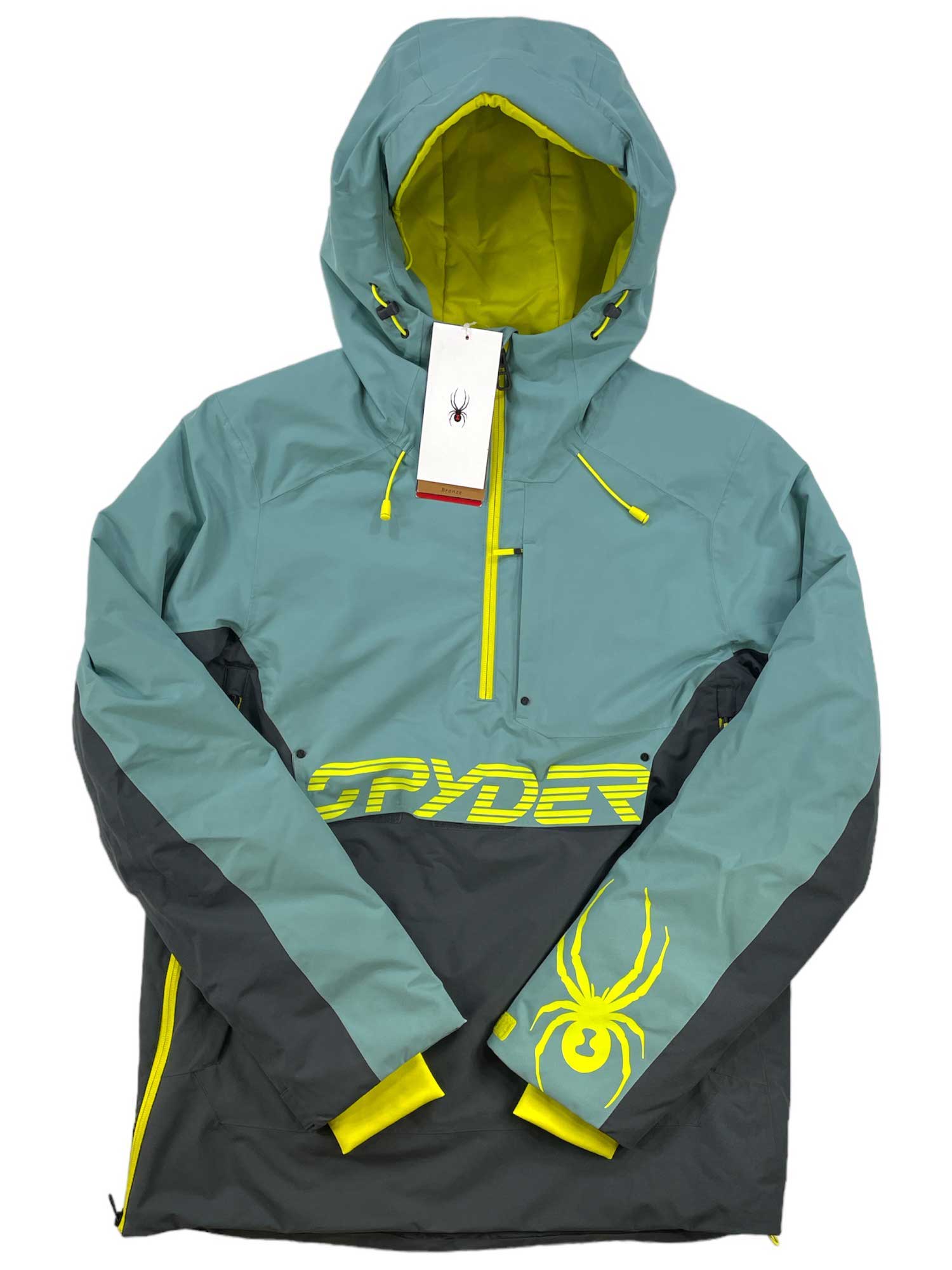 The Spyder Mens Signal Anorak is a teal and dark gray ski jacket with PrimaLoft insulation, yellow accents, chest zipper pocket, and yellow spider logo. "SPYDER" is printed in yellow on the front. A tag with the spider logo hangs from the zipper.