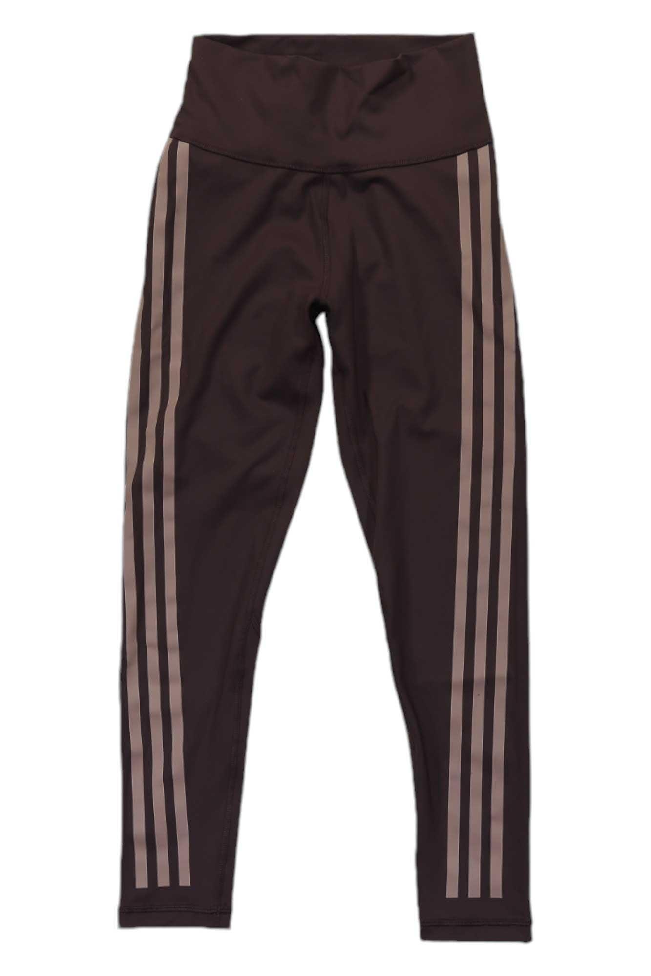 The Adidas Womens Optime 3S Train Icons 7/8 Tight are black high-rise leggings with a wide waistband and three beige stripes down each leg. Moisture-wicking for comfort during workouts. Shown laid flat on a white background.