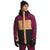 Wearing The North Face Men's Freedom Insulated Jacket in maroon, tan, and black—with Heatseeker Eco insulation—a black beanie, maroon pants, and black gloves, a person stands against a white background with the hood up, looking to the side.