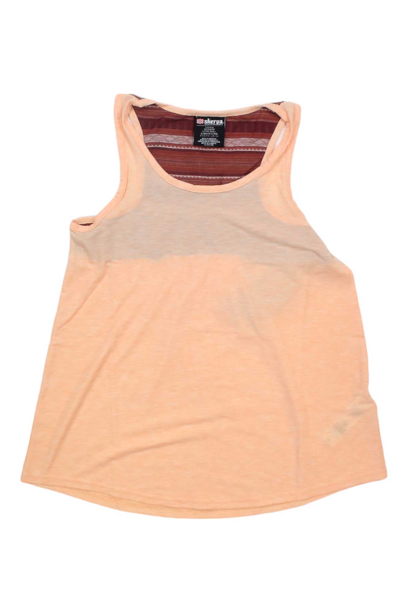 The Sherpa Womens Asha Tank is a peach-colored, sleeveless top with a rounded neckline, slightly flared hem, and maroon striped inner lining. Made from moisture-wicking drirelease fabric with a visible clothing tag.