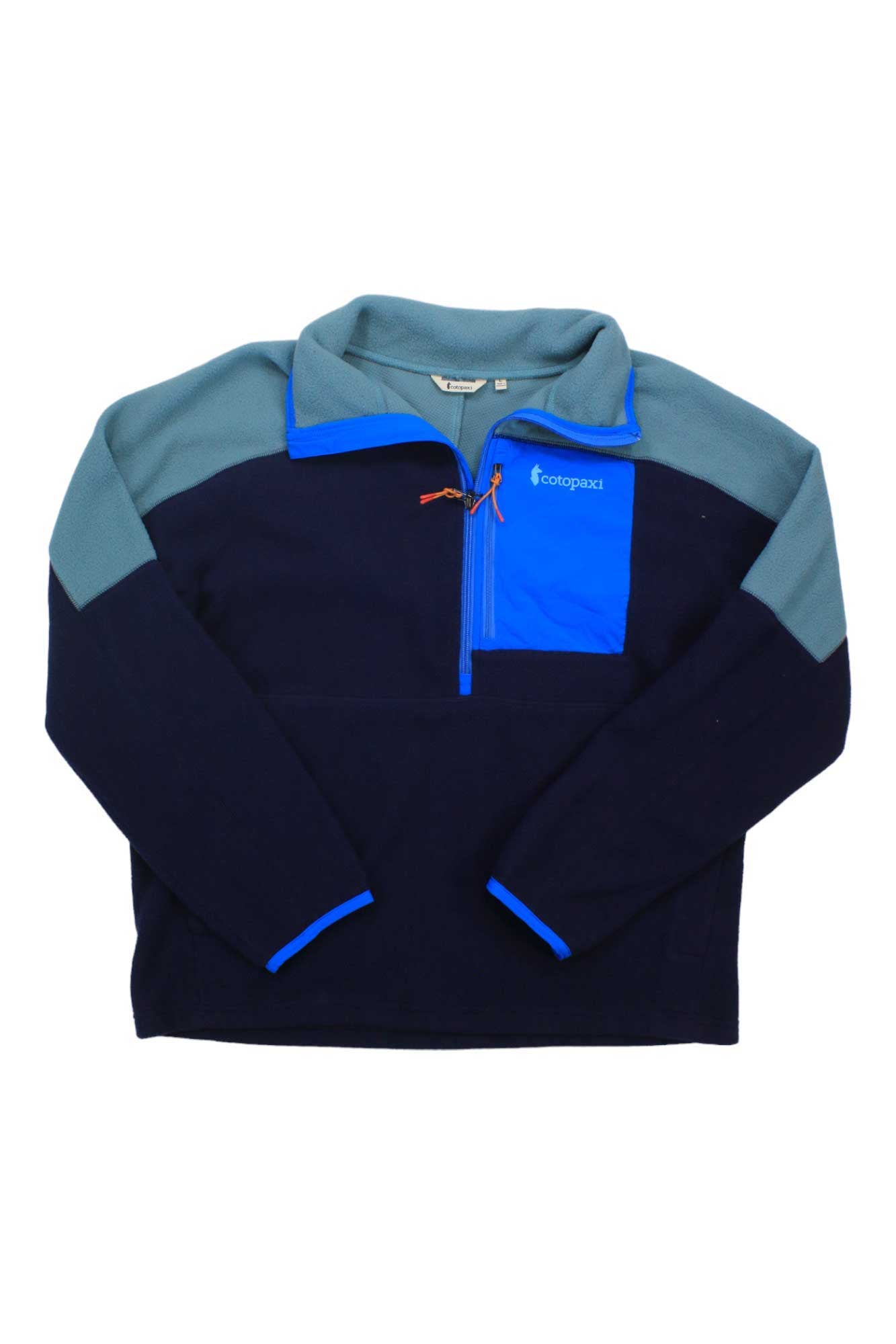 The Cotopaxi Mens Abrazo Half-Zip Fleece Jacket is a men's colorblock fleece made from recycled polyester, featuring dark, light, and bright blue panels, a stand-up collar, chest zip pocket, and long sleeves.