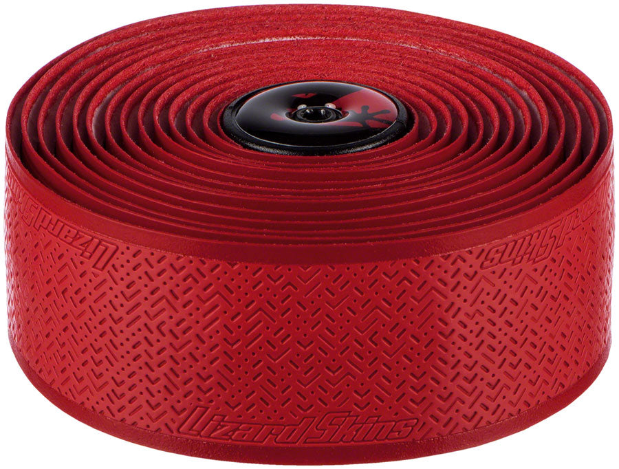 The Lizard Skins DSP Bar Tape V2 - 1.8 MM is a textured, shock-absorbing red bar tape with the brand name embossed and a black bar end plug—ideal for comfortable cycling.