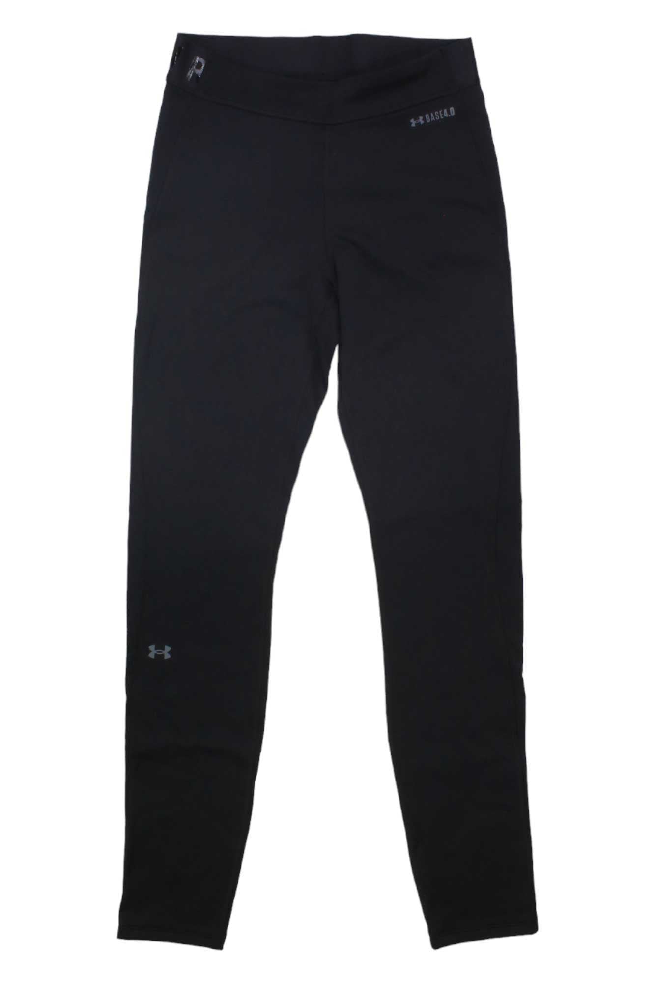 Under Armour Women's Packaged Base 4.0 Legging in black is shown laid flat on a white surface, with a small Under Armour logo on the left thigh, HeatGear label near the waistband, and moisture-wicking comfort for baselayer use.