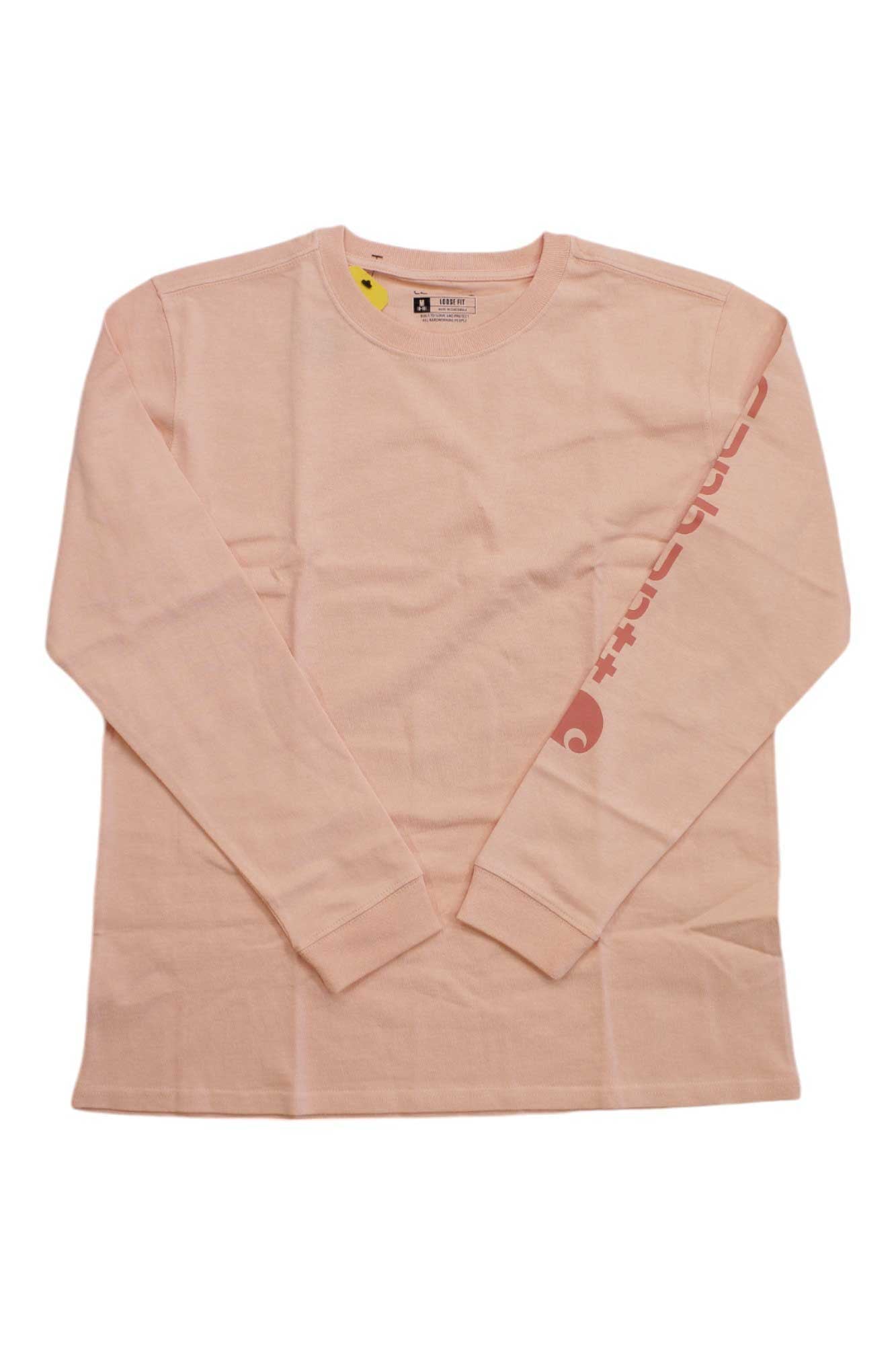 The Carhartt Women's Loose Fit Heavyweight Pocket LS T-Shirt is light pink with a round neckline, long sleeves, a pocket, and red graphic text down the right sleeve. The tee is displayed flat on a white background.