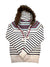 The Faux Fur Full Zip Hooded Knit Sweater is a white knit hoodie with black stripes, Nordic patterns, a faux fur-trimmed hood, two white pom-pom drawstrings, and a small heart logo on the front.