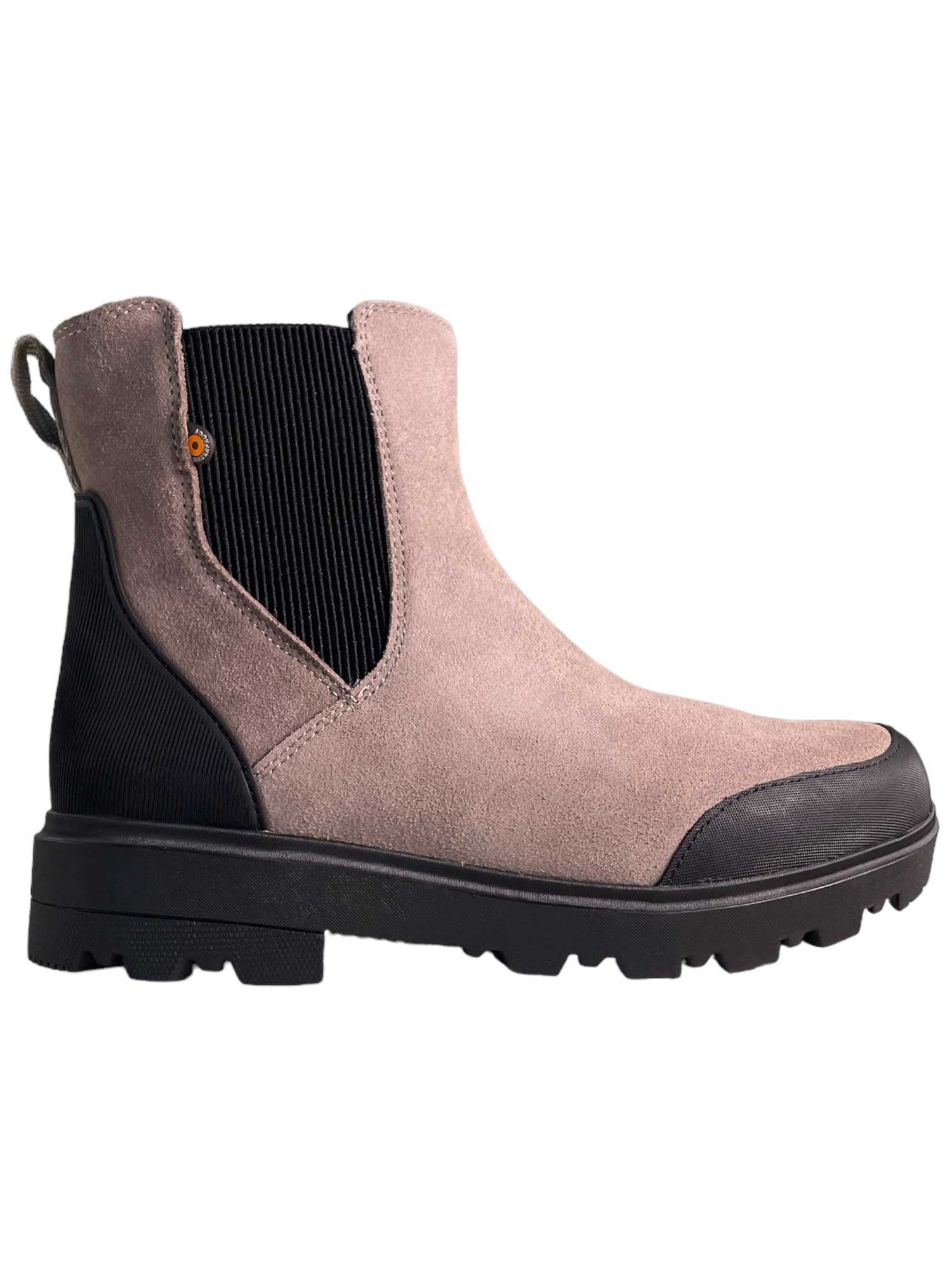 The Bogs Womens Holly Chelsea Leather Boot features light brown suede, a black ribbed elastic side panel, black pull tab, and a durable black rubber sole and toe cap. This eco-friendly boot is shown in a right-facing side view.
