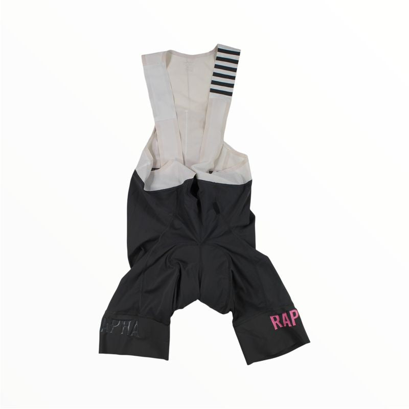 The Rapha Mens Pro Team Bib Shorts II - Long feature beige shoulder straps, a black and white striped strap detail, dual-density chamois for comfort, and white and pink RAPHA text on each leg. Shown on a white background.