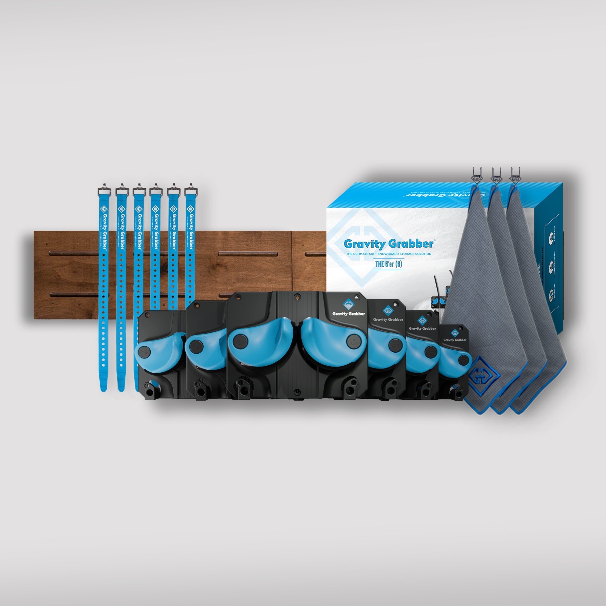 The Cyan Bundle Maple Board kit is displayed with four black and blue wall mounts, a maple board panel, four blue straps, a cyan box, and three gray towels on a light gray background.