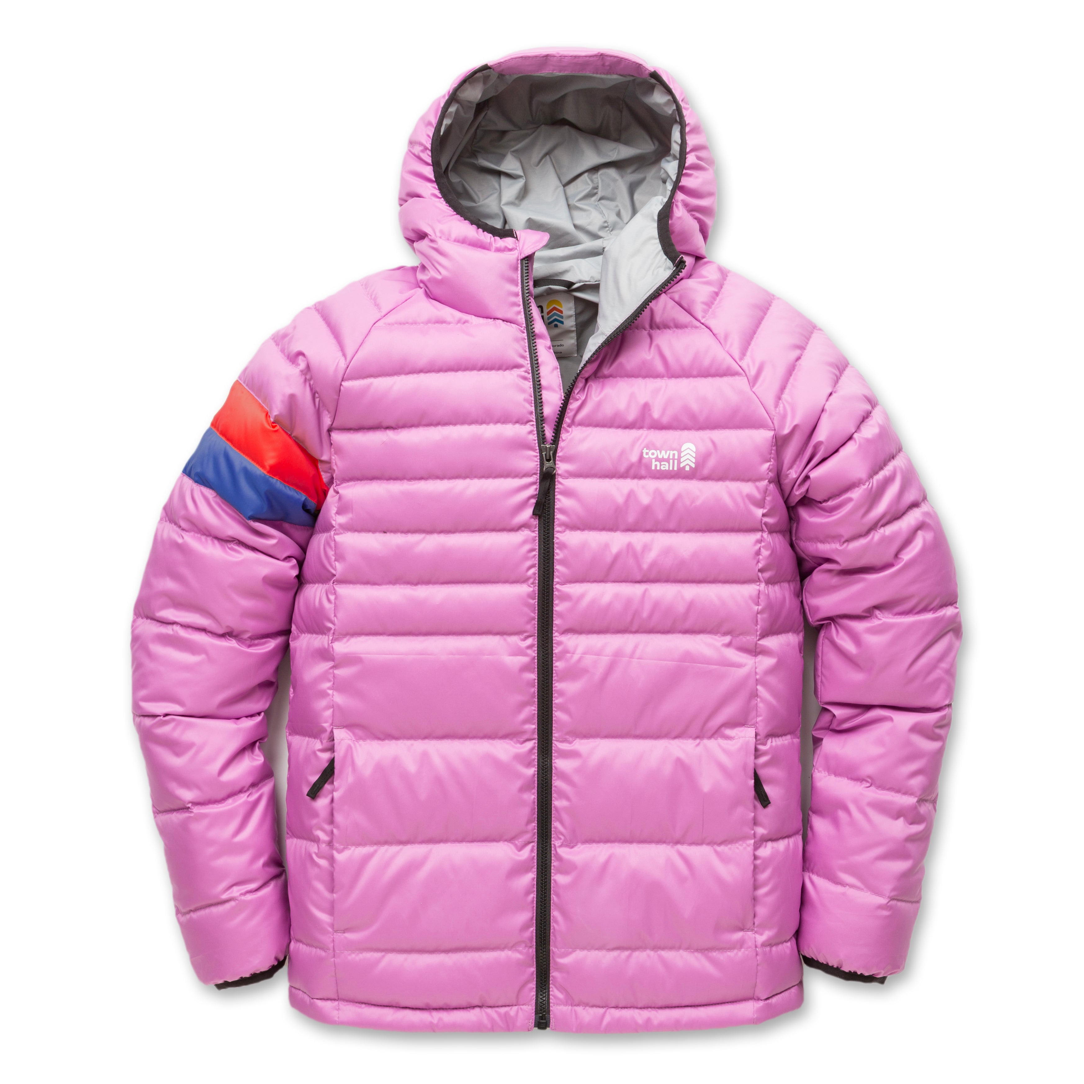 The Down Town Kids Puffy is a pink hooded puffer jacket with a black zipper, side pockets, blue and red stripes on the left sleeve, and a small white chest logo. Made with recycled down insulation for a sustainable winter coat option.