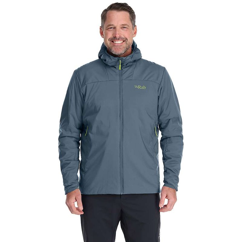 A man smiles with his hands at his sides, modeling the blue Rab Mens Xenair Alpine Light Jacket—a lightweight mountaineering jacket featuring warm Primaloft insulation—against a white background.