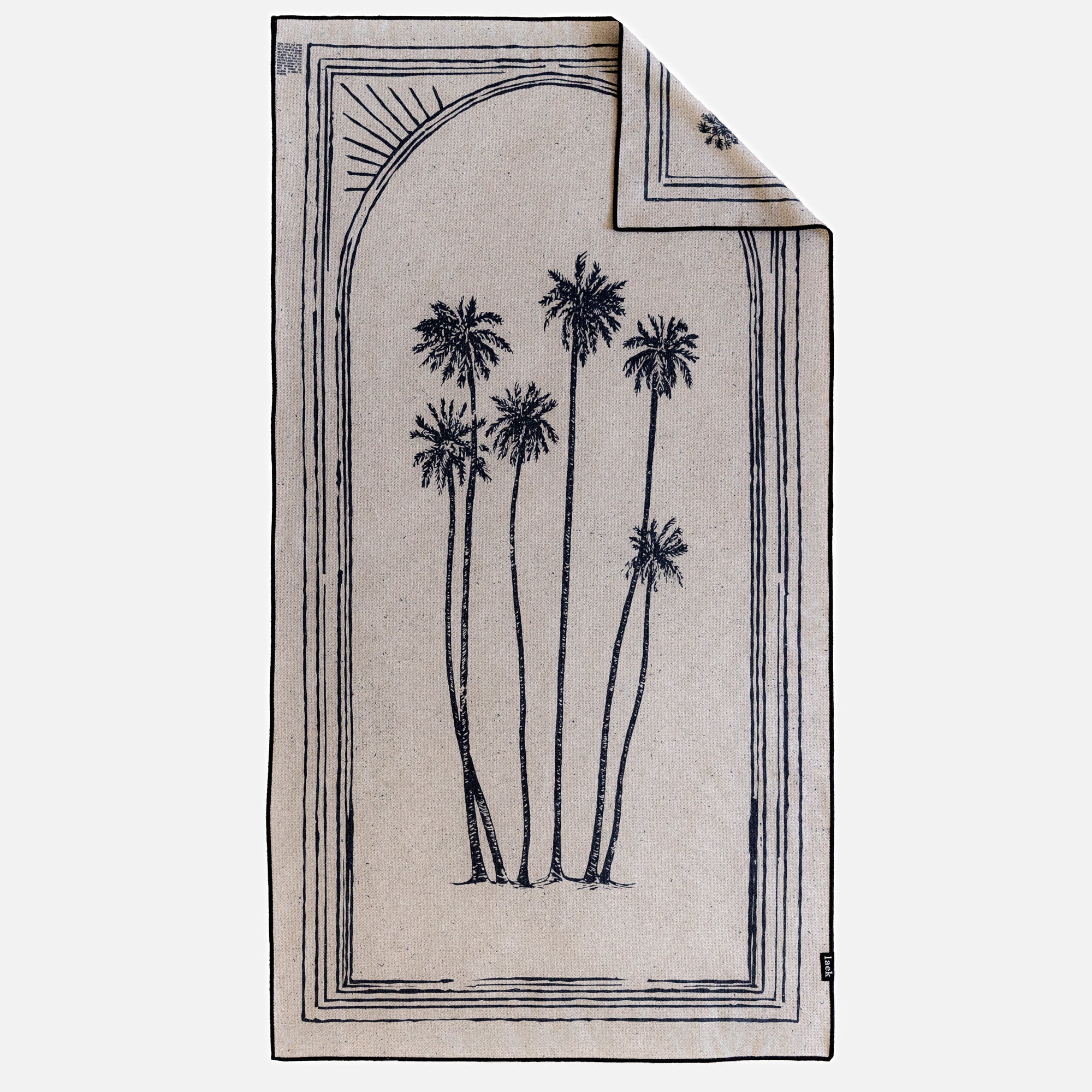 The Beach Towel is beige and oversized, with a black line drawing of tall palm trees centered, bordered by a geometric frame and a partial sun in the top left. Its sand-free design makes it ideal for sunny getaways. One corner is folded over in the image.